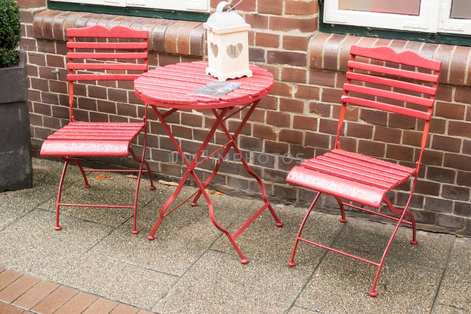 Table and two chairs in red with water drops by sandra_fotodesign