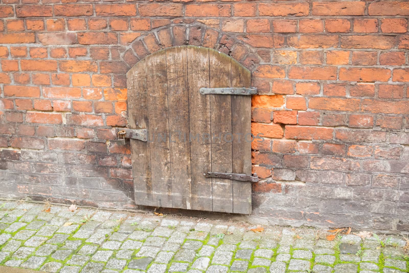 Small wooden door with lock in stone wall