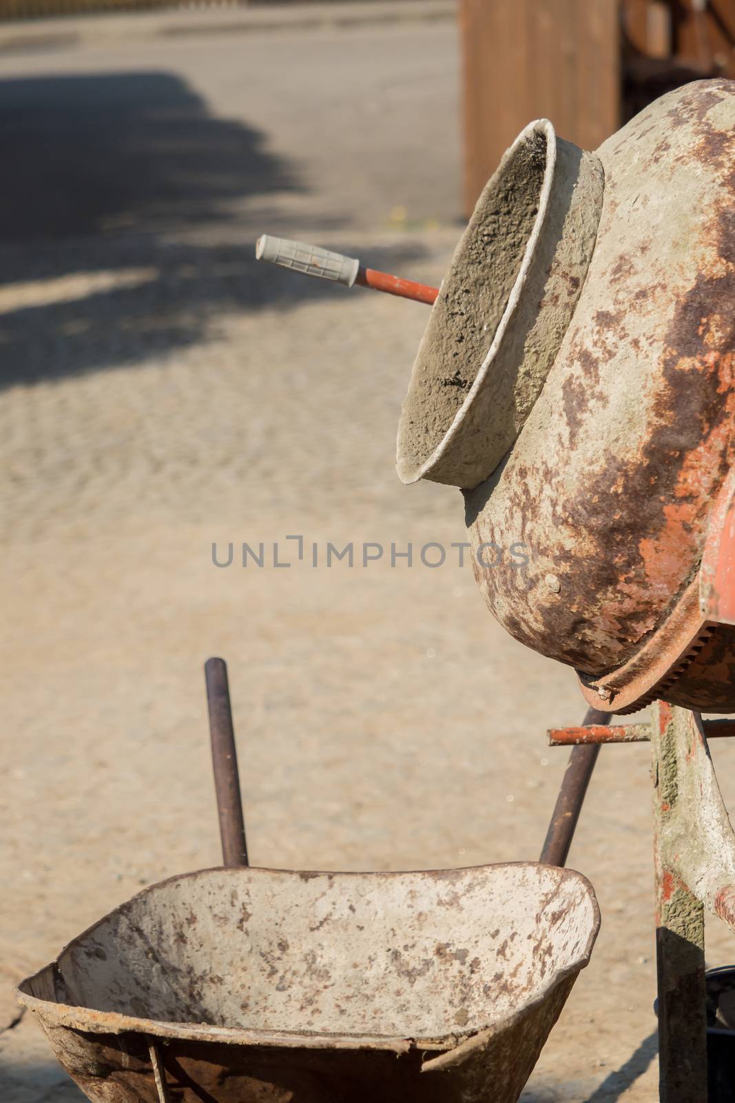 Construction site work with concrete mixer and wheelbarrows by sandra_fotodesign