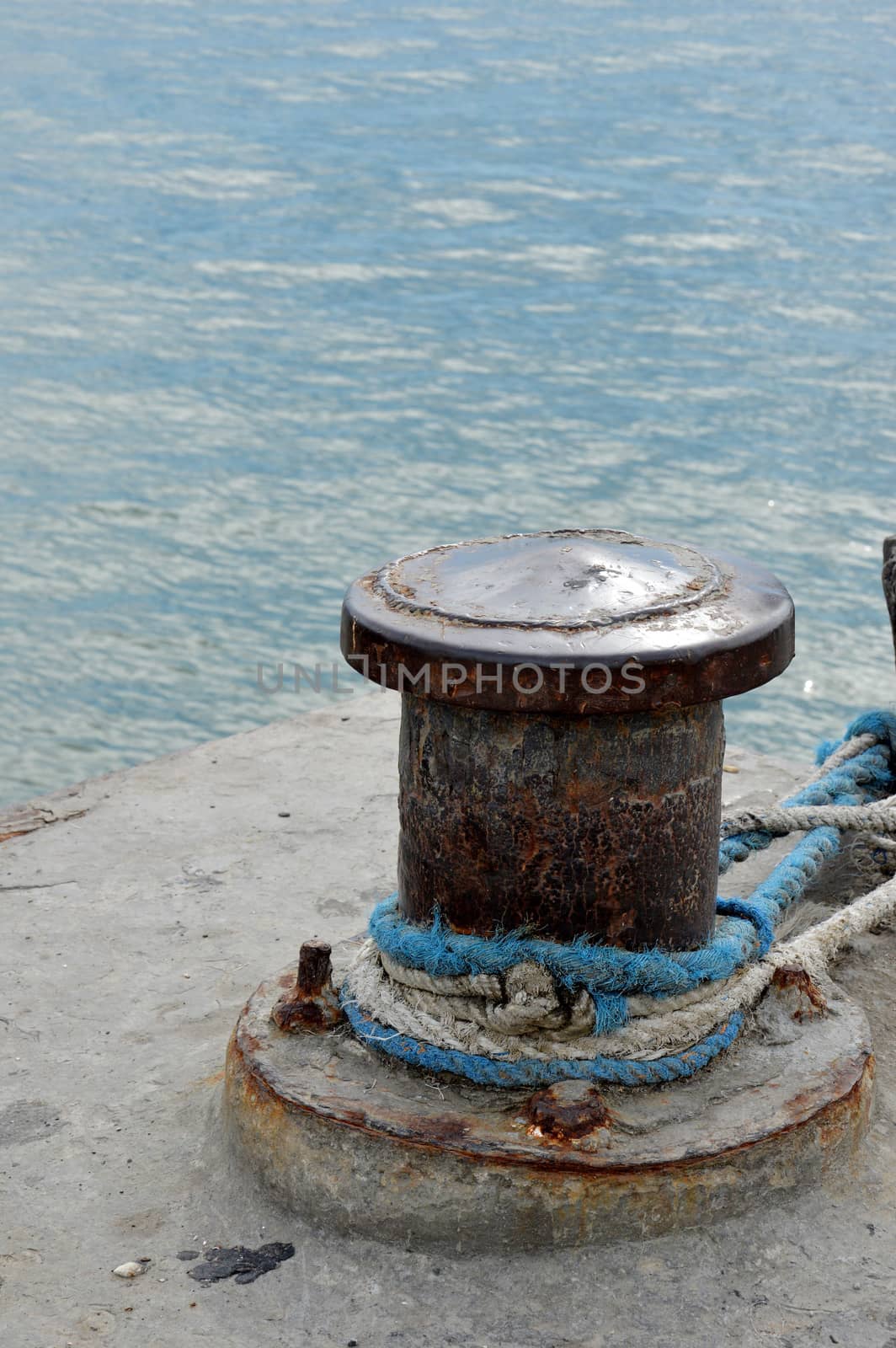 Rusty mooring bollard with ship ropes by antonihalim