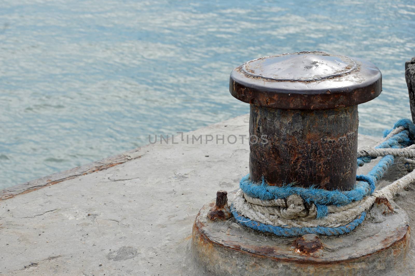 Rusty mooring bollard with ship ropes by antonihalim