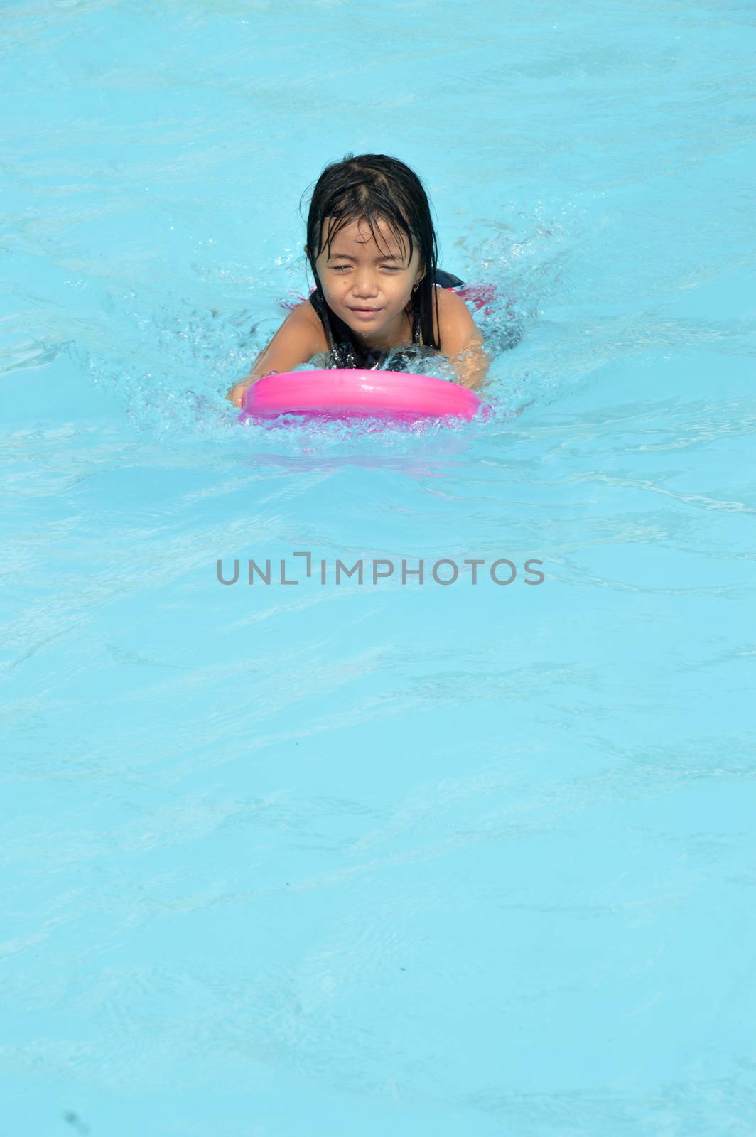 asian little girl playing in the pool by antonihalim