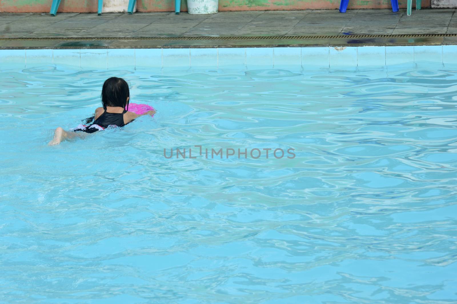 asian little girl playing in the pool