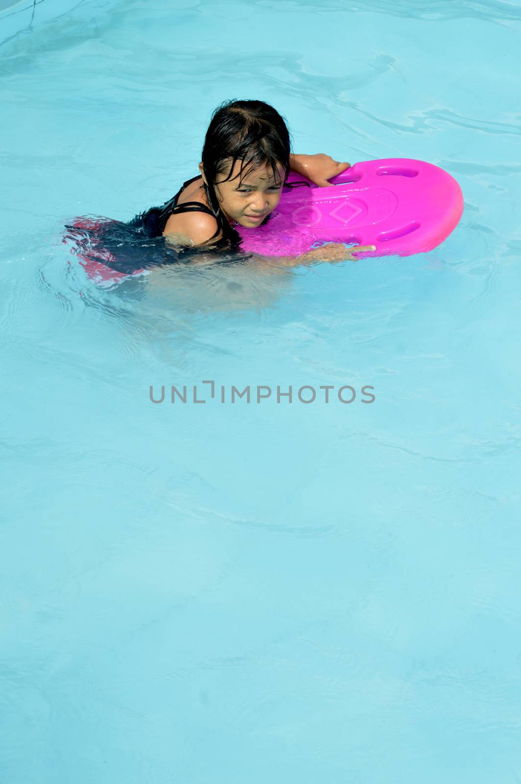 asian little girl playing in the pool by antonihalim