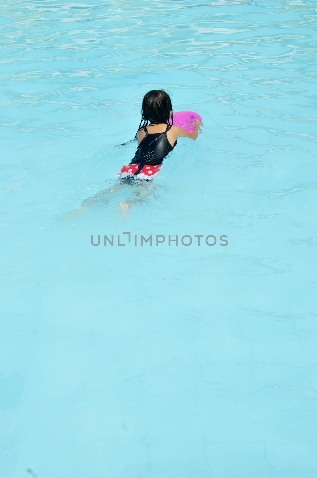 asian little girl playing in the pool