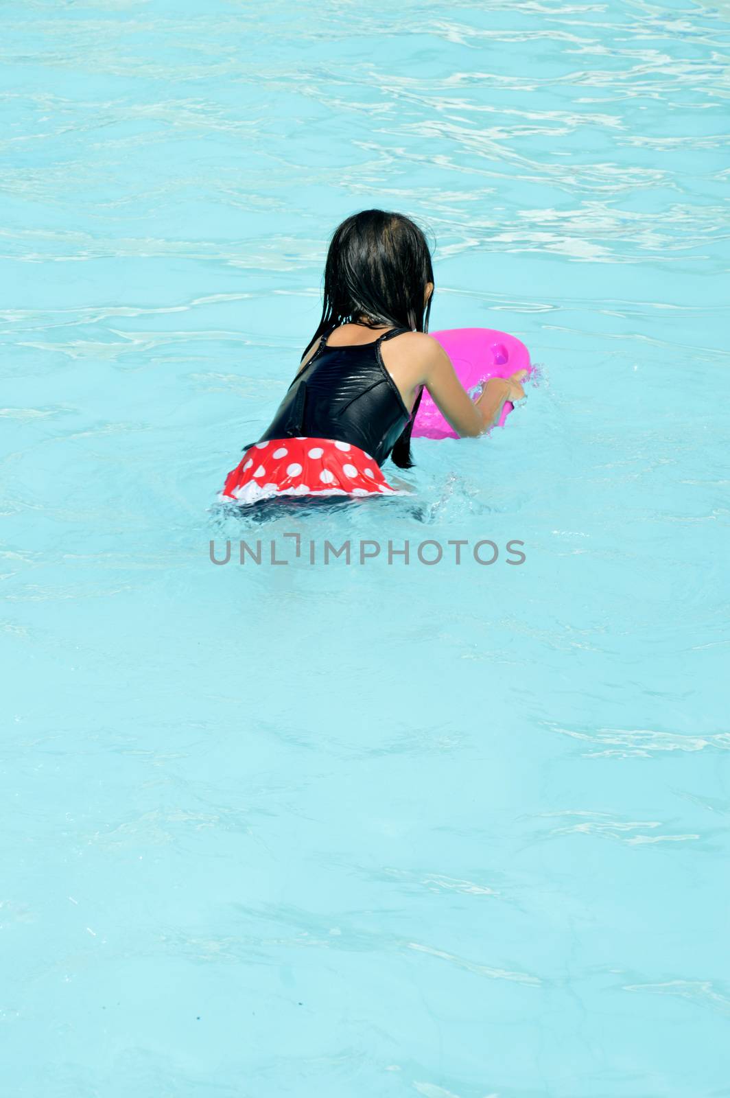 asian little girl playing in the pool