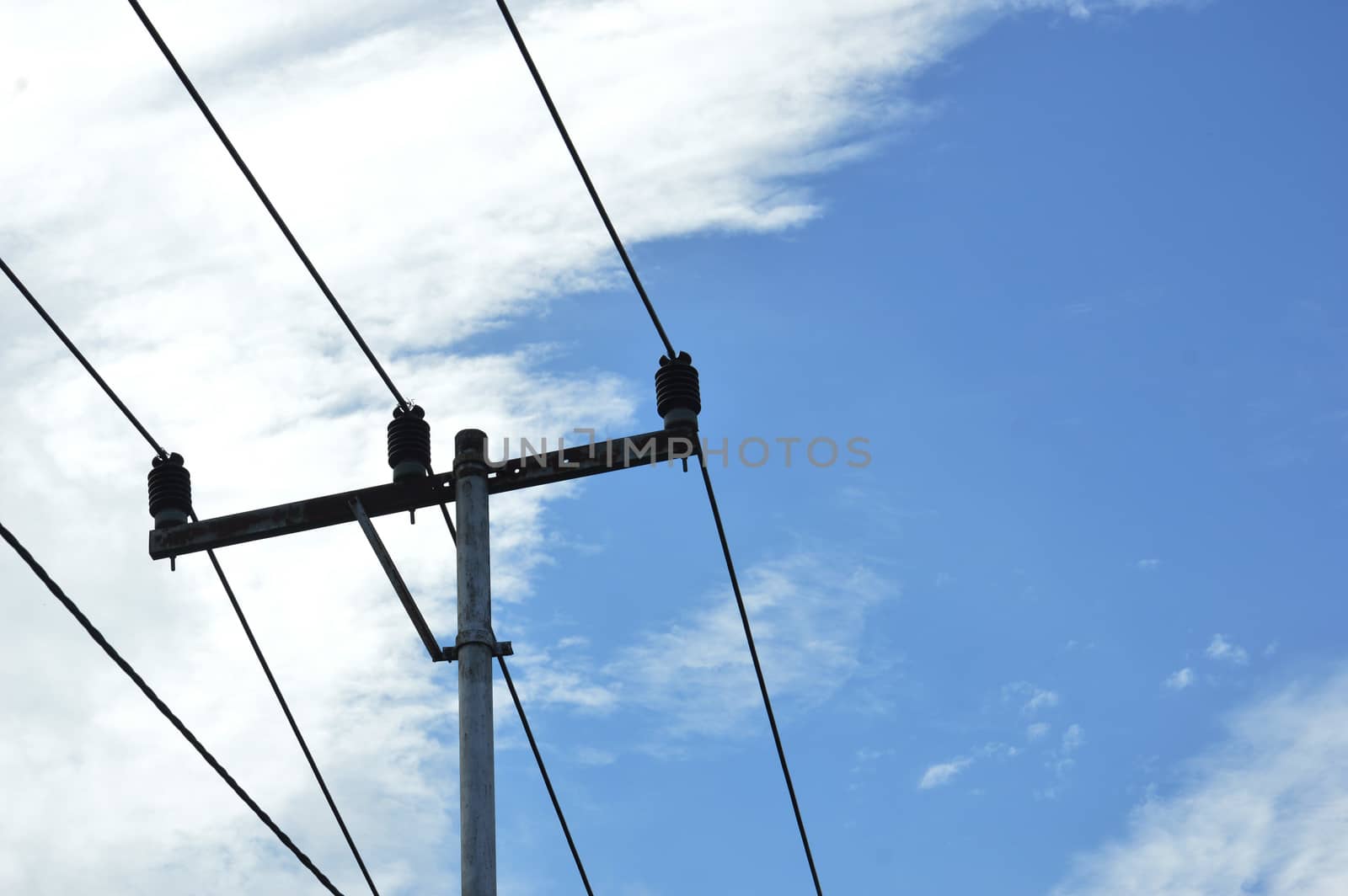 electricity poles against blue sky