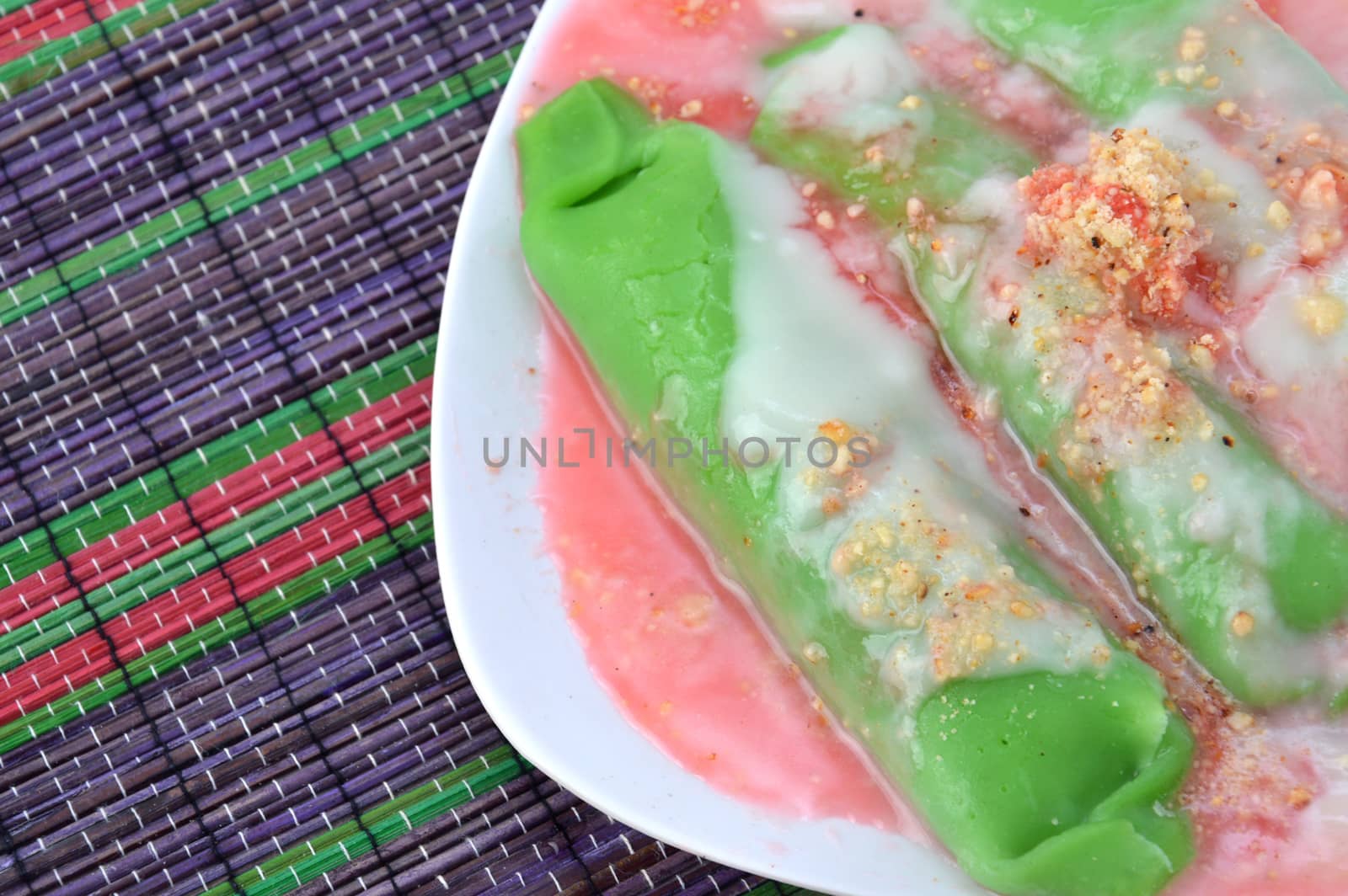 pisang ijo ice or green banana ice a tradisonal snack foods from ethnic Bugis or Makassar made of ripe banana pancakes wrapped in pandan leaf extract gravy with fla, syrup,milk and peanut powder