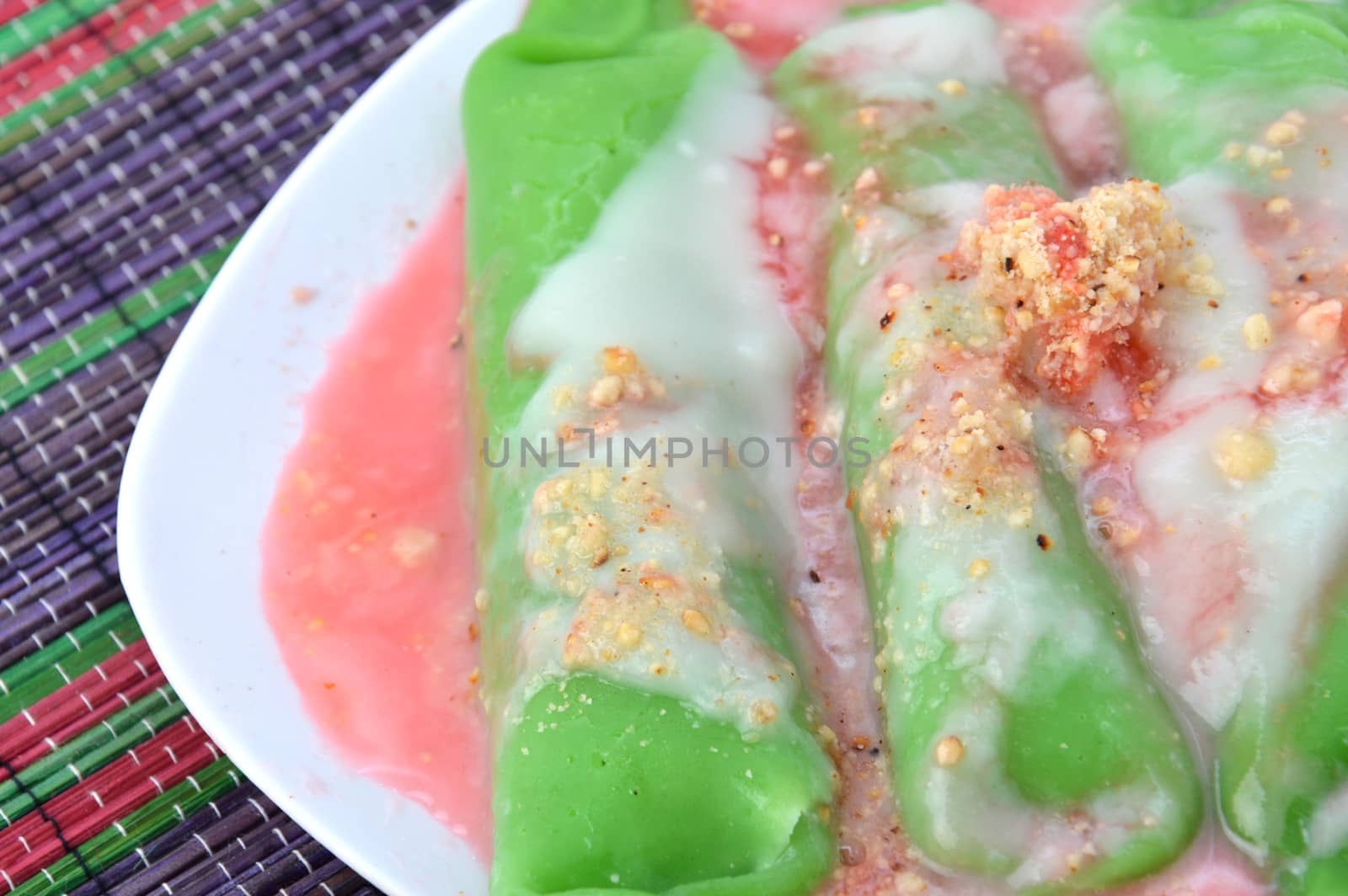 pisang ijo ice or green banana ice a tradisonal snack foods from ethnic Bugis or Makassar made of ripe banana pancakes wrapped in pandan leaf extract gravy with fla, syrup,milk and peanut powder