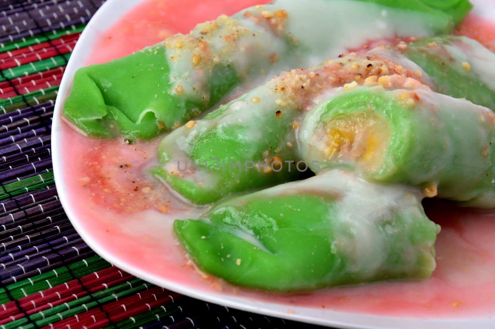 pisang ijo ice or green banana ice a tradisonal snack foods from ethnic Bugis or Makassar made of ripe banana pancakes wrapped in pandan leaf extract gravy with fla, syrup,milk and peanut powder