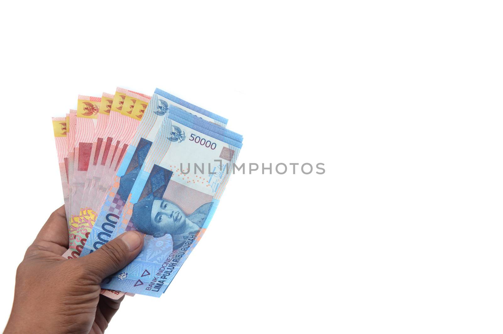 male hand hold Indonesian paper money on white background