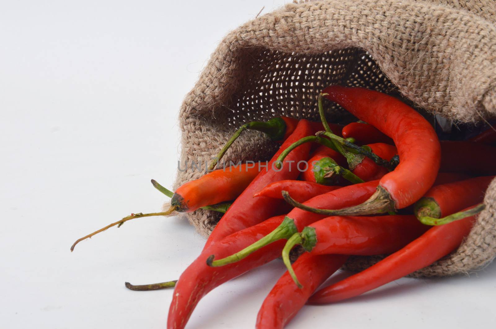 big chili red in a burlap sack on white background