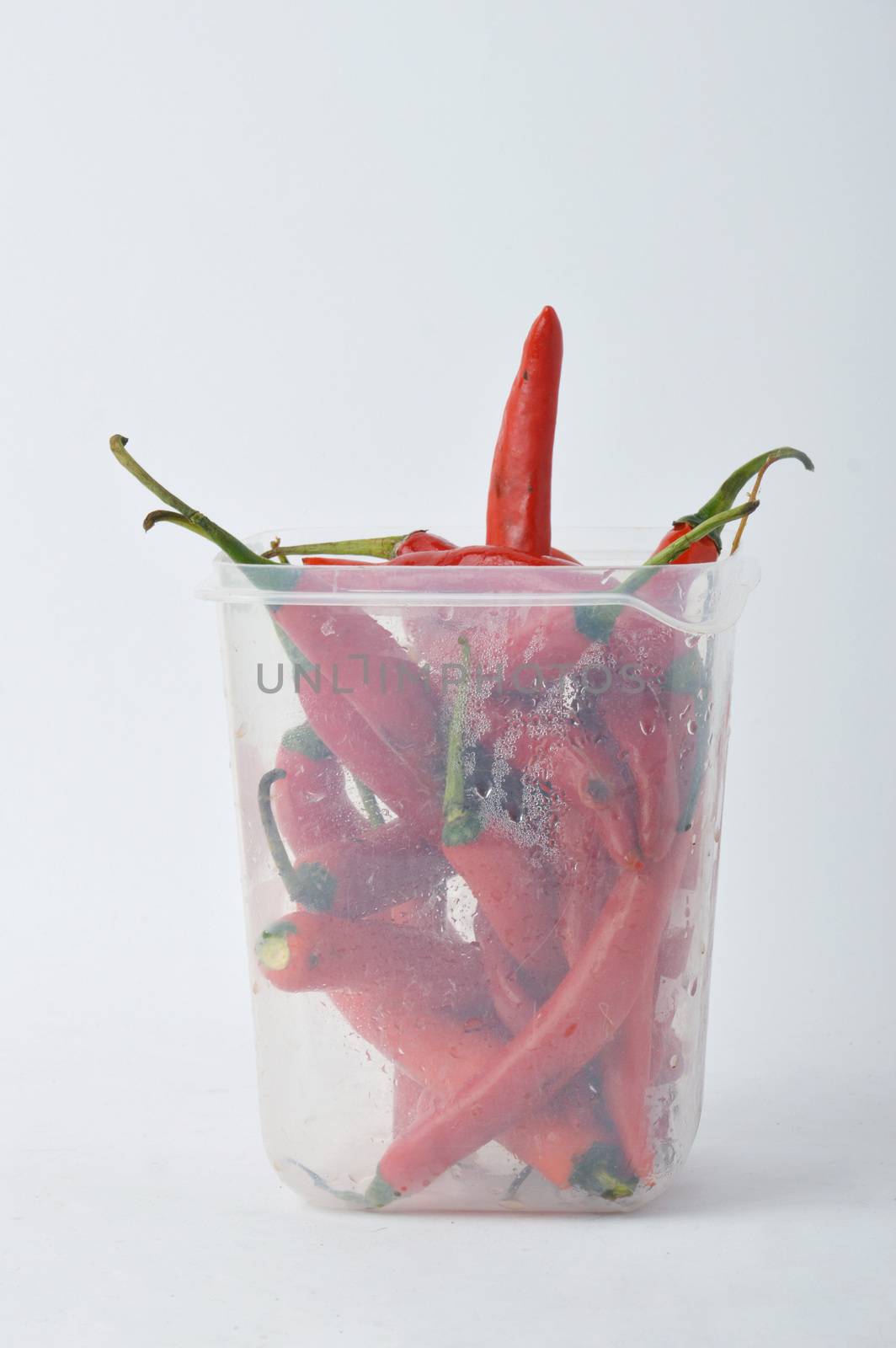 big chili red in a plastic jar on white background