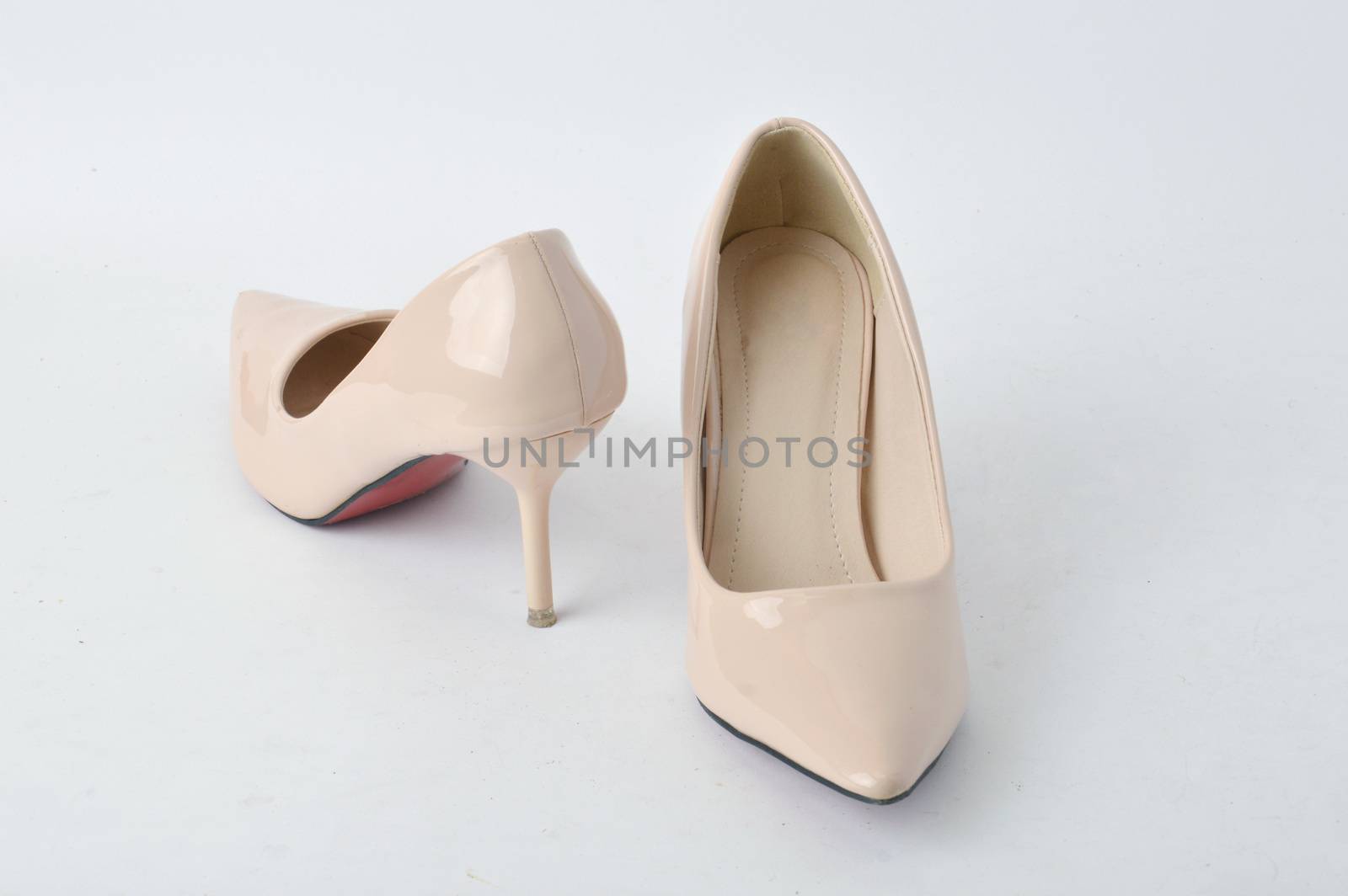 beige high heel shoes on white background