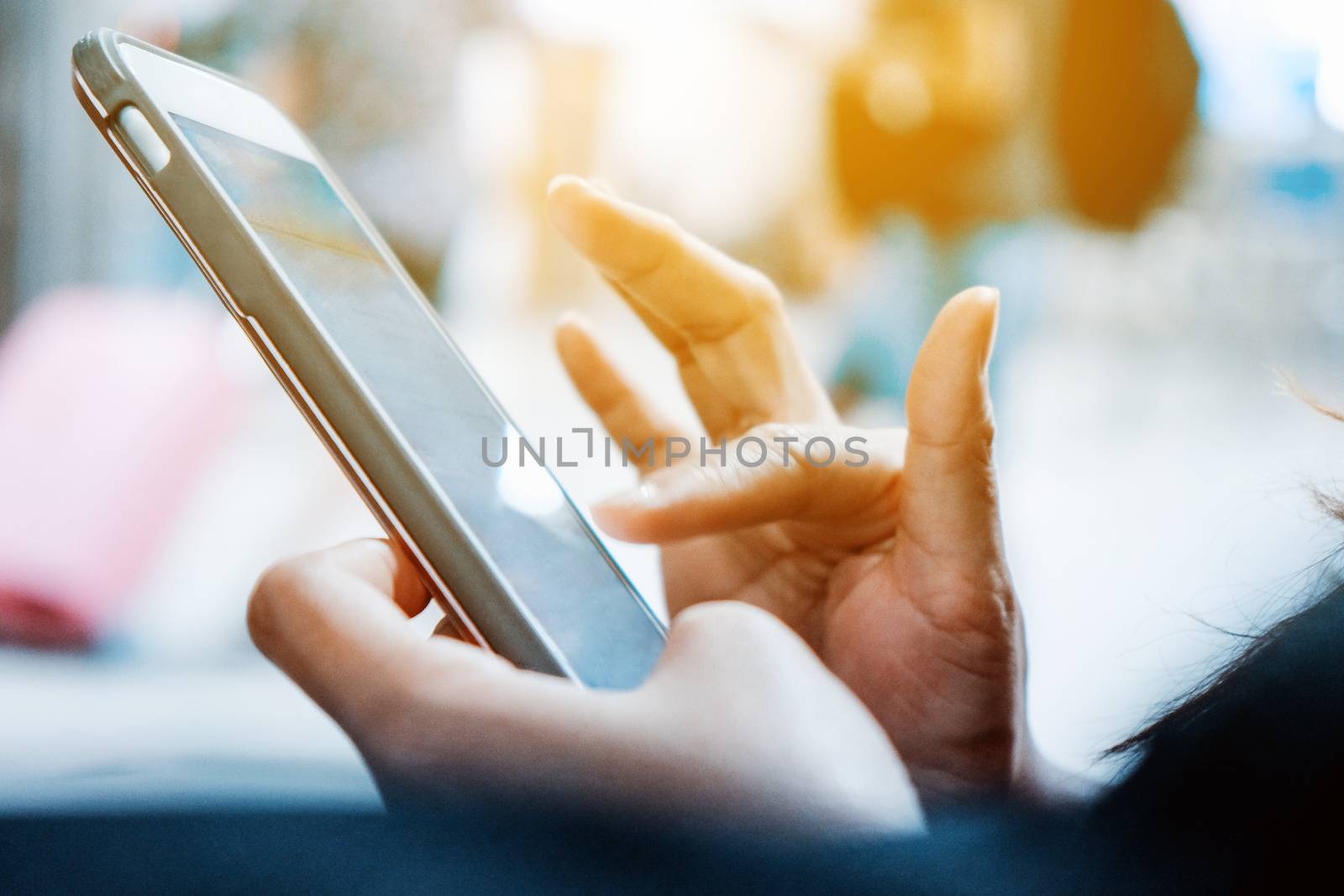 Closeup image of woman's hands holding and touching a smartphone
