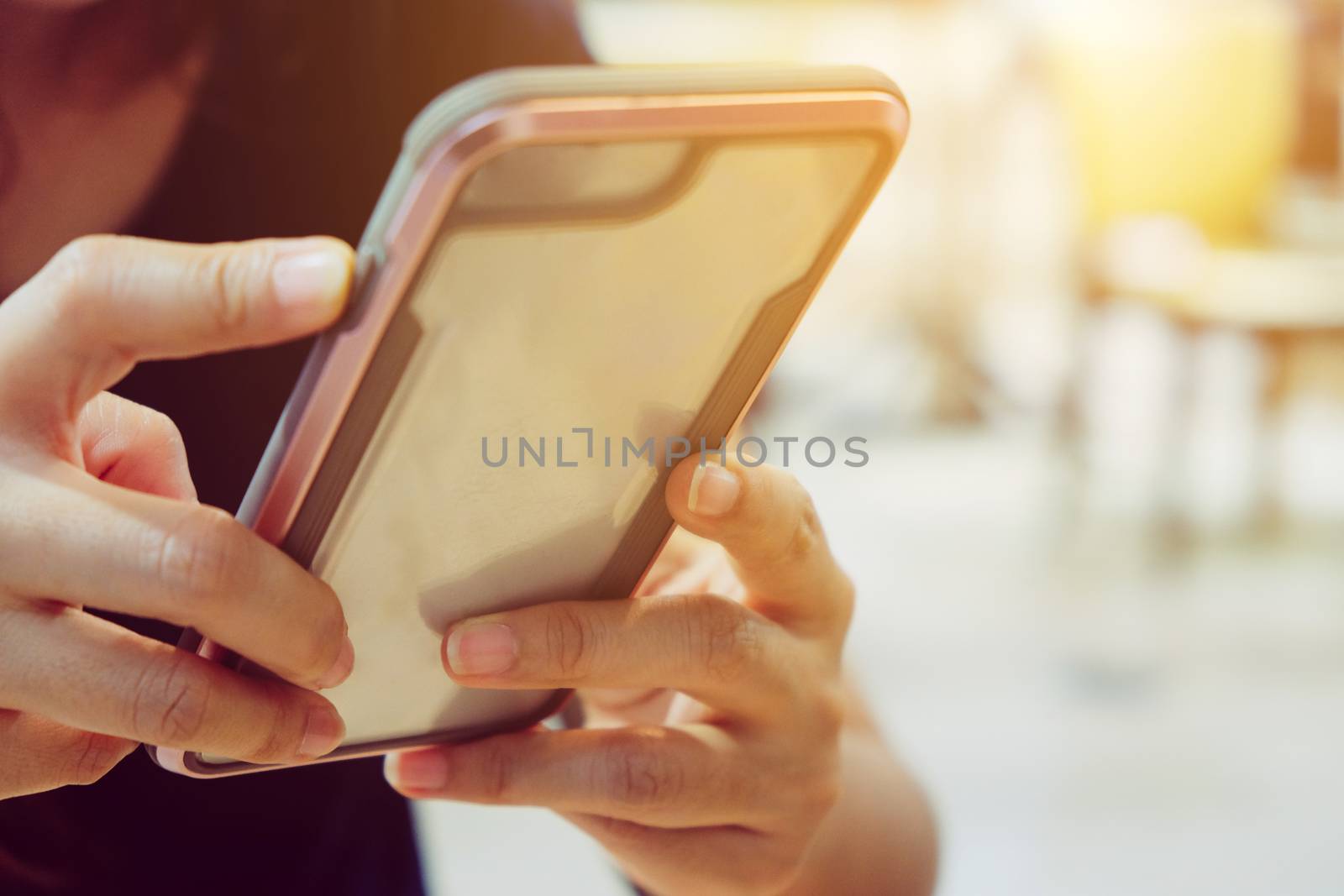 Closeup image of woman's hands holding and touching a smartphone