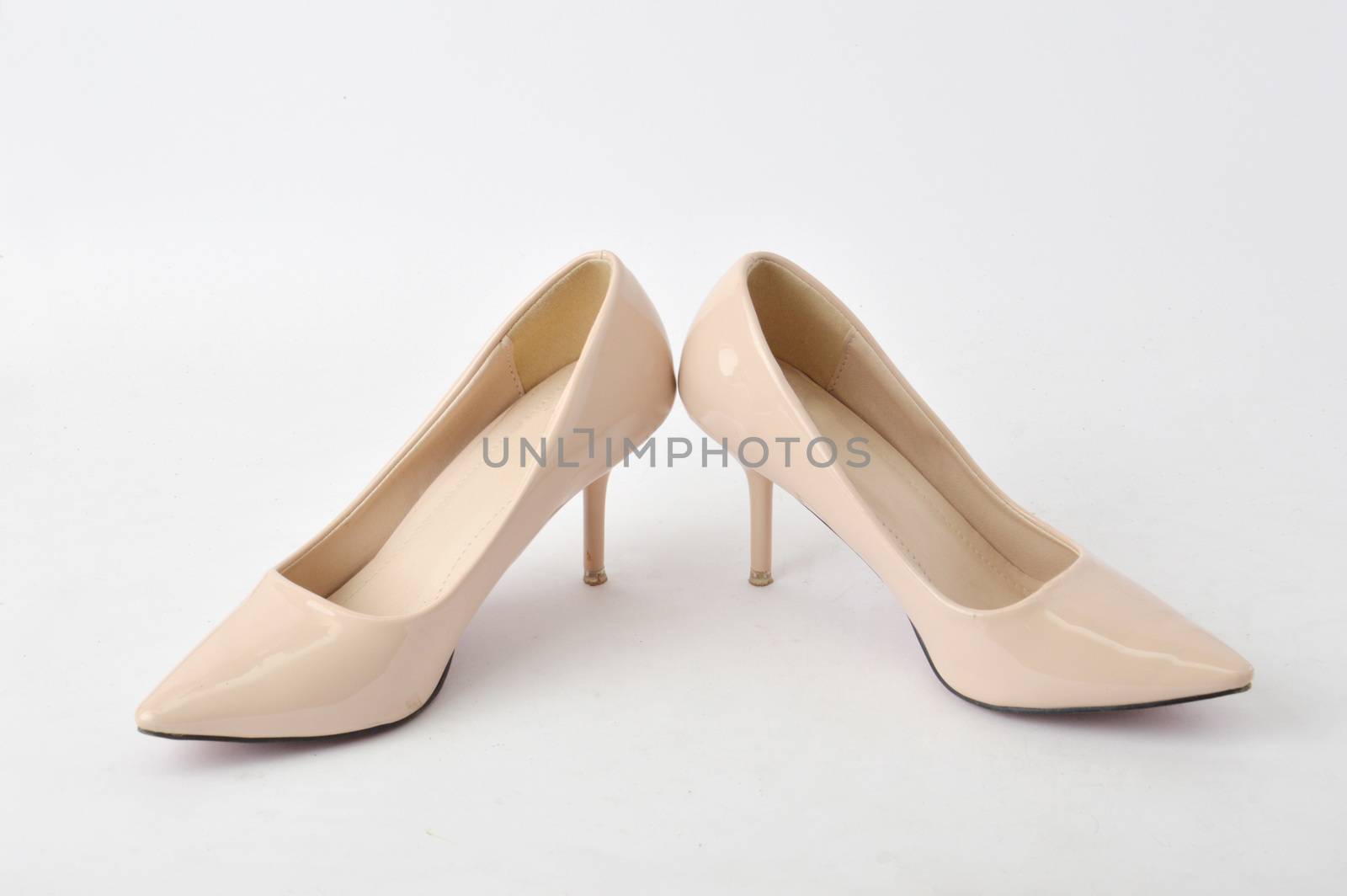 beige high heel shoes on white background