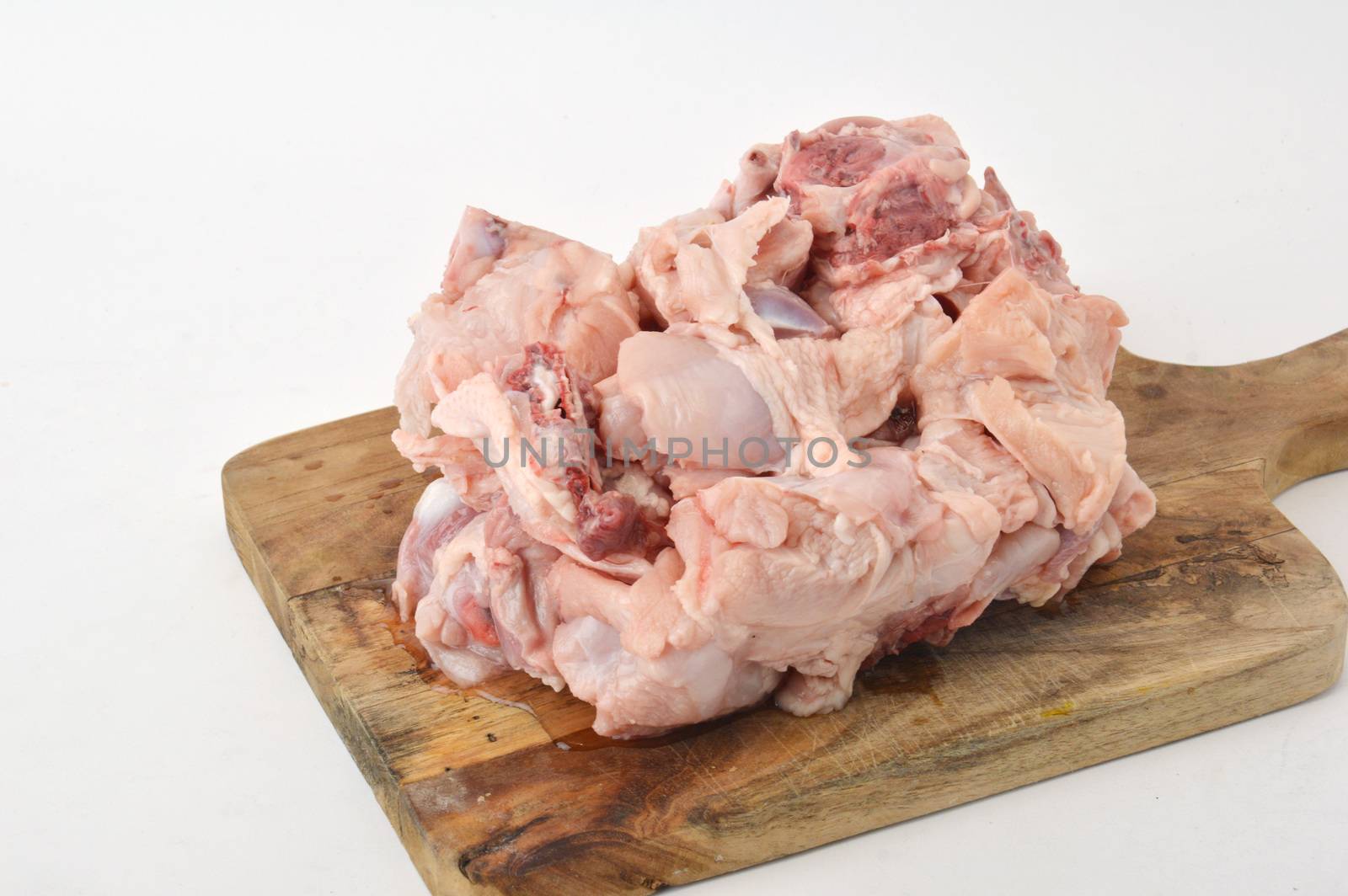 frozen raw chicken meat on board chopped with white background