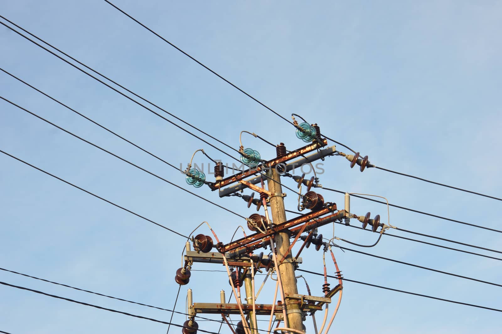 electricity poles against blue sky