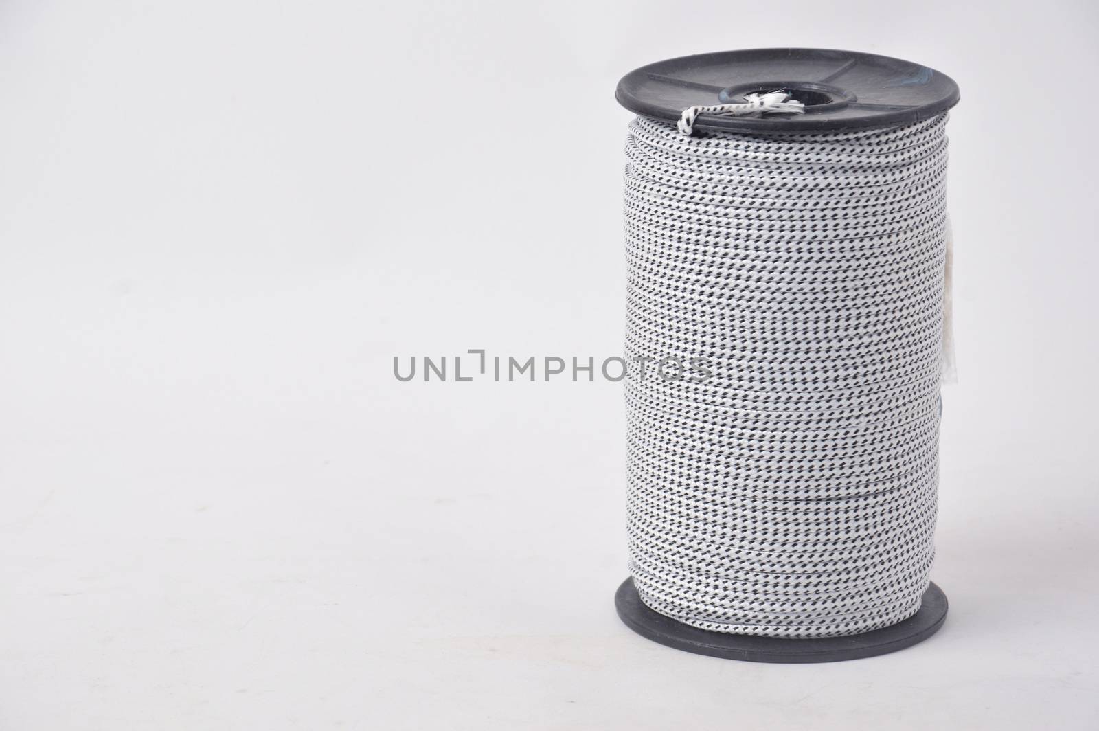 black and white spools of thread on white background