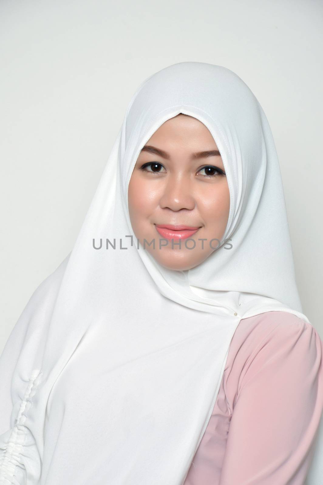 portrait of a beautiful muslim woman wearing a headscarf on white background