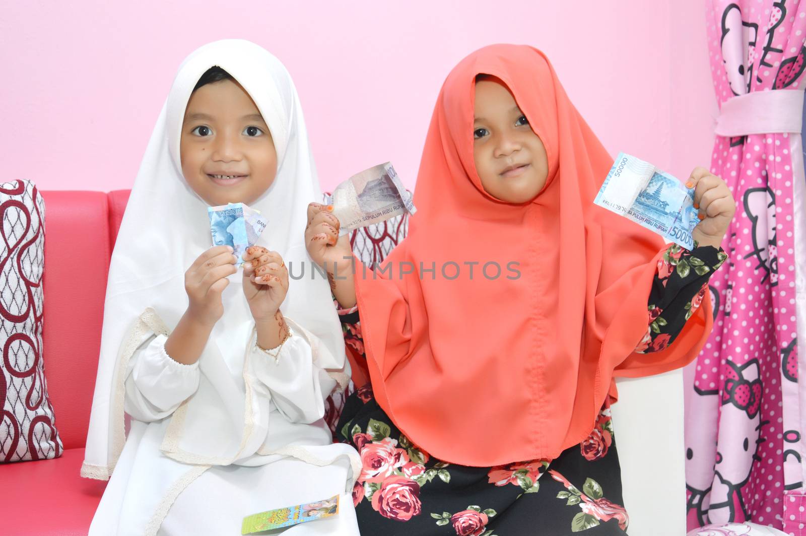 two Asian little girl Muslim showing results giving money visiting at Eid