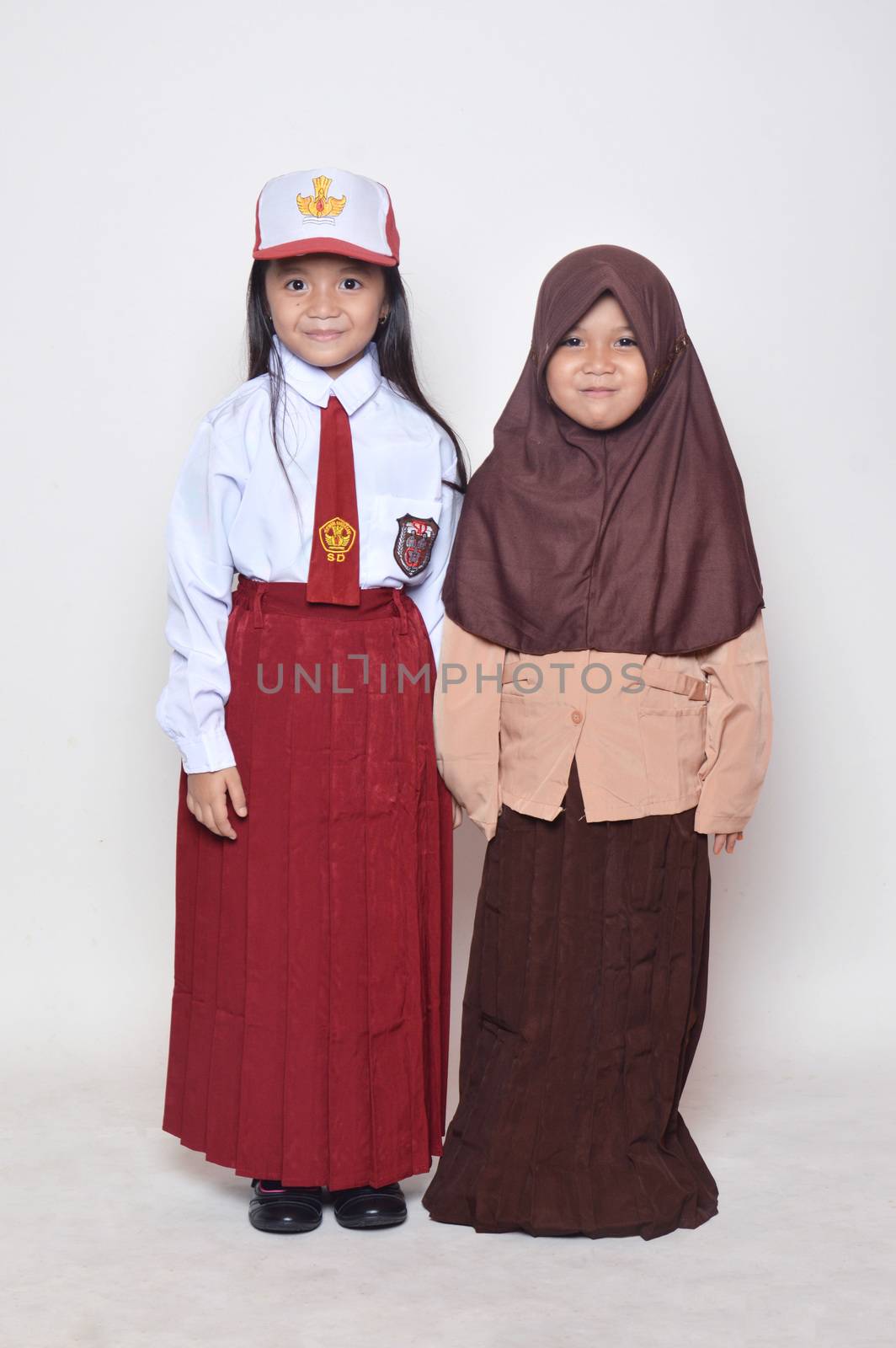 two asian little girl with primary school uniform and girl scout uniform