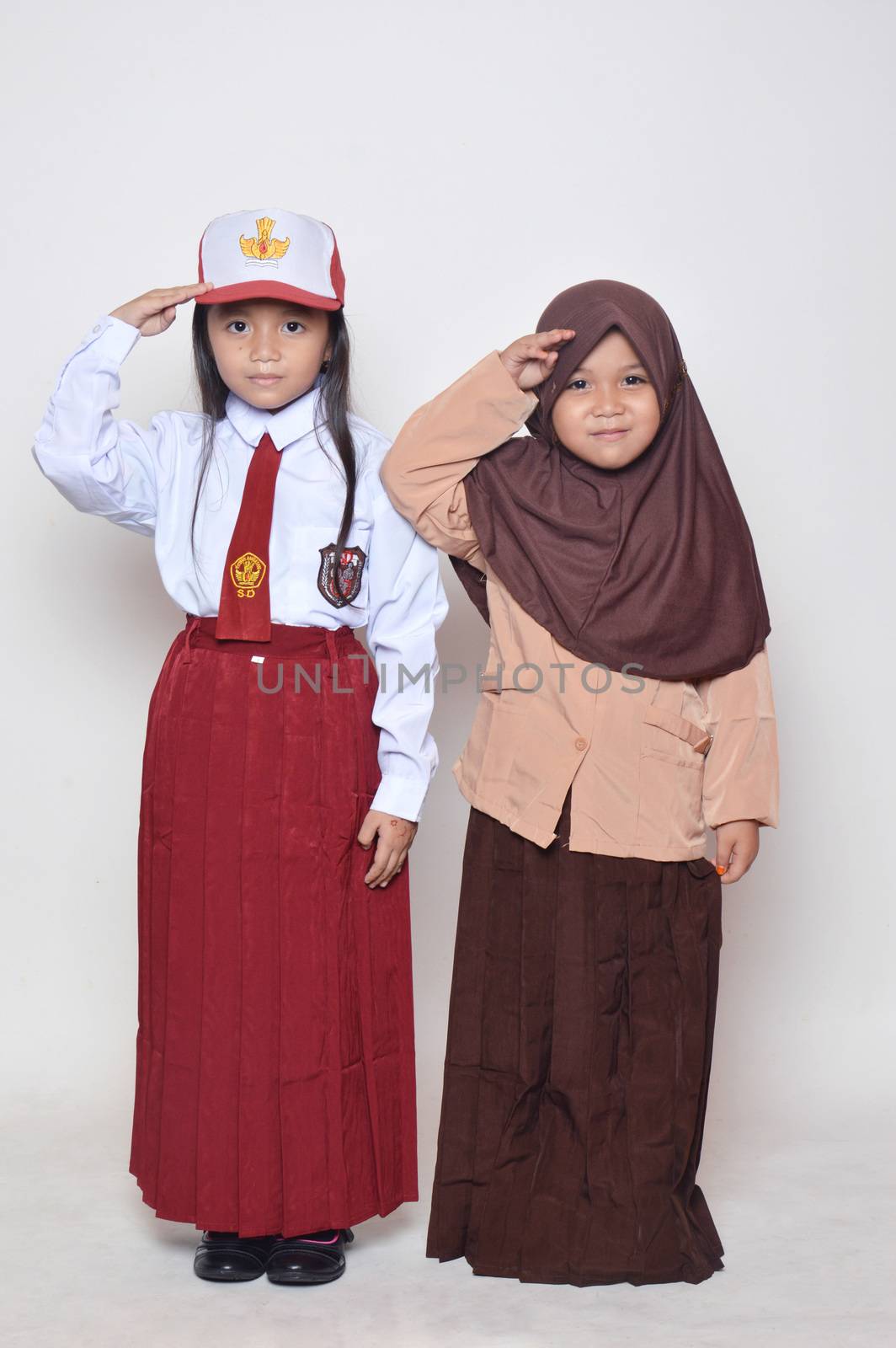 two asian little girl with primary school uniform and girl scout uniform