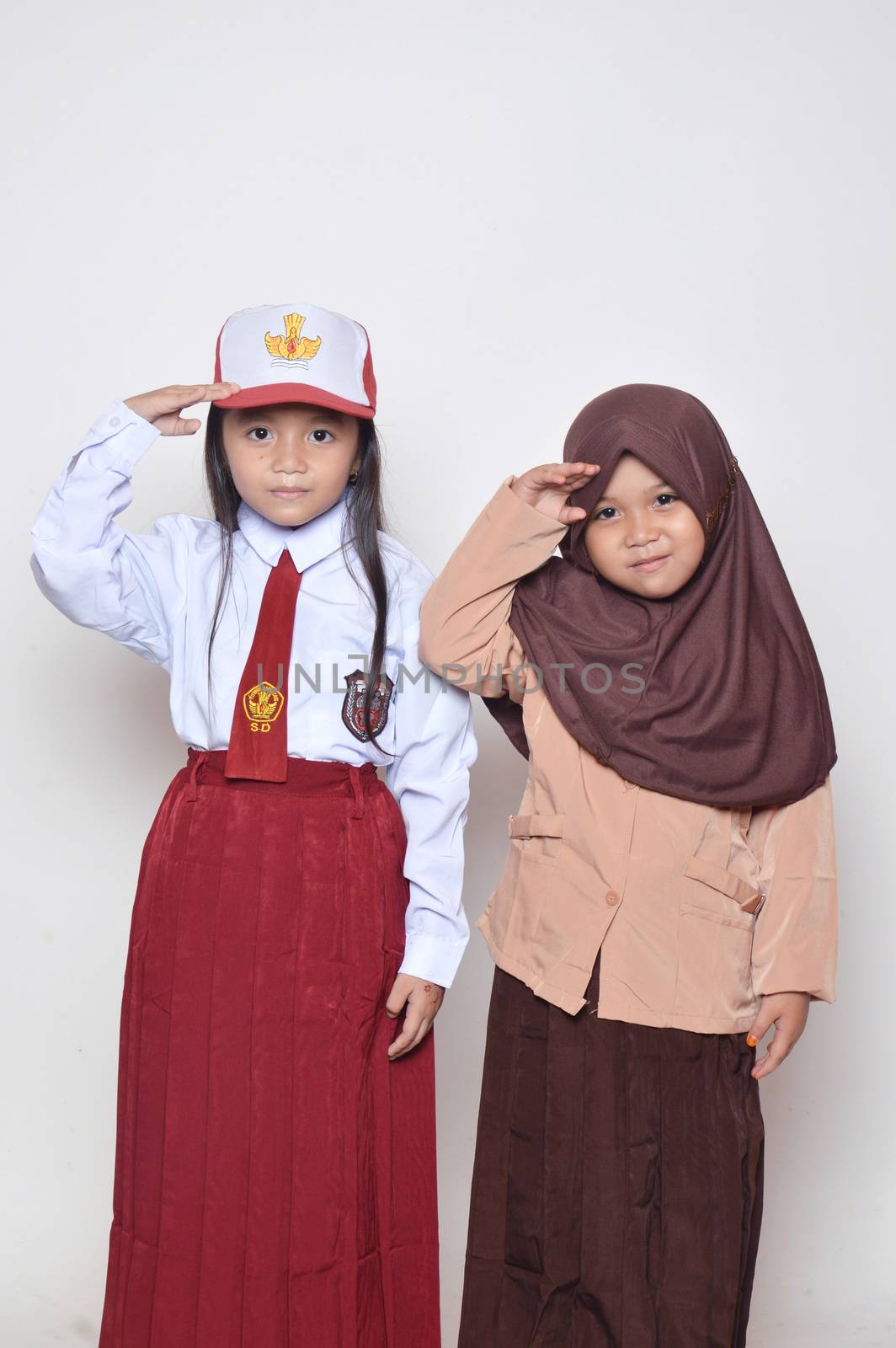 two asian little girl with primary school uniform and girl scout uniform