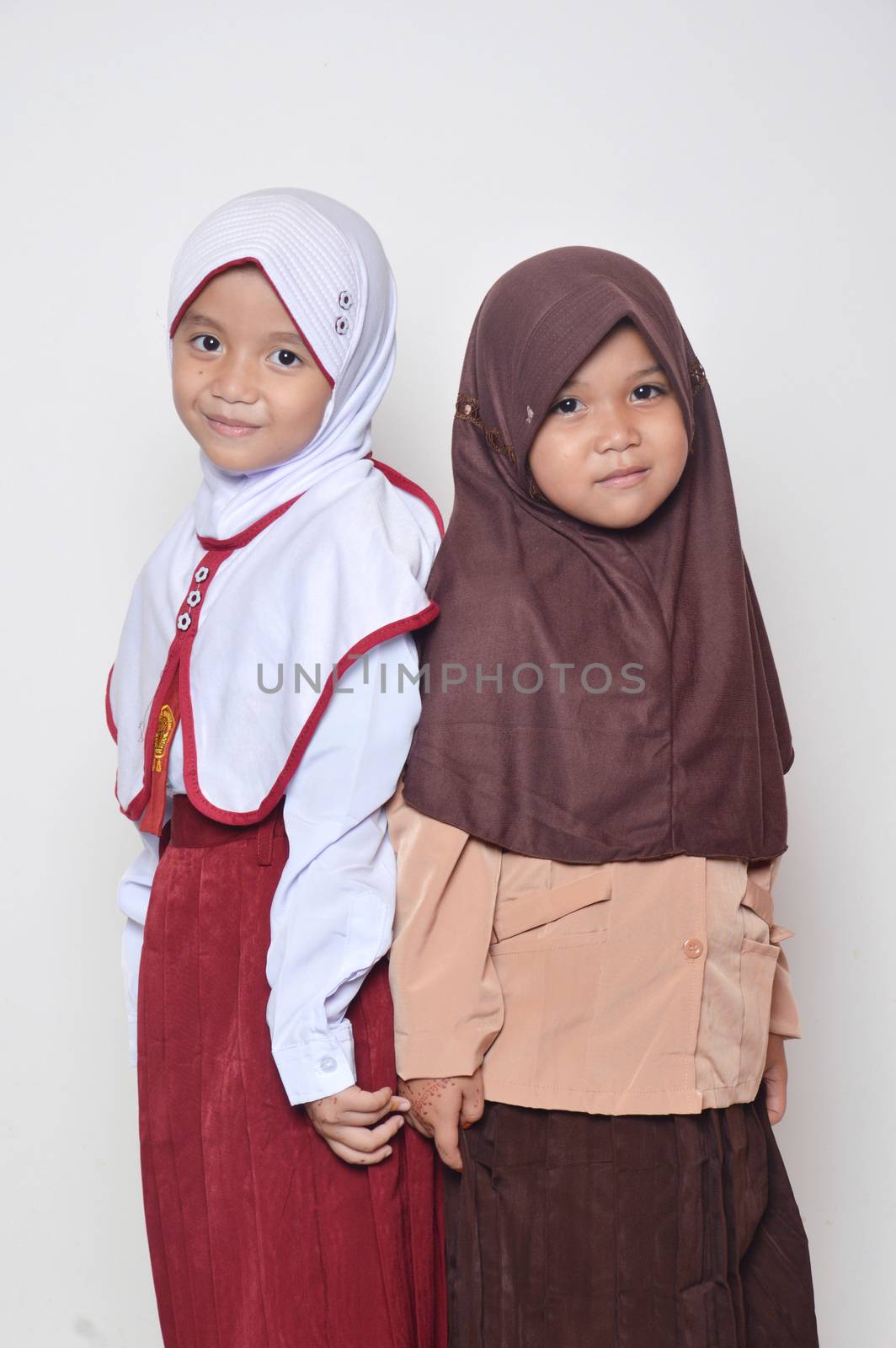 two asian little girl with primary school uniform and girl scout uniform