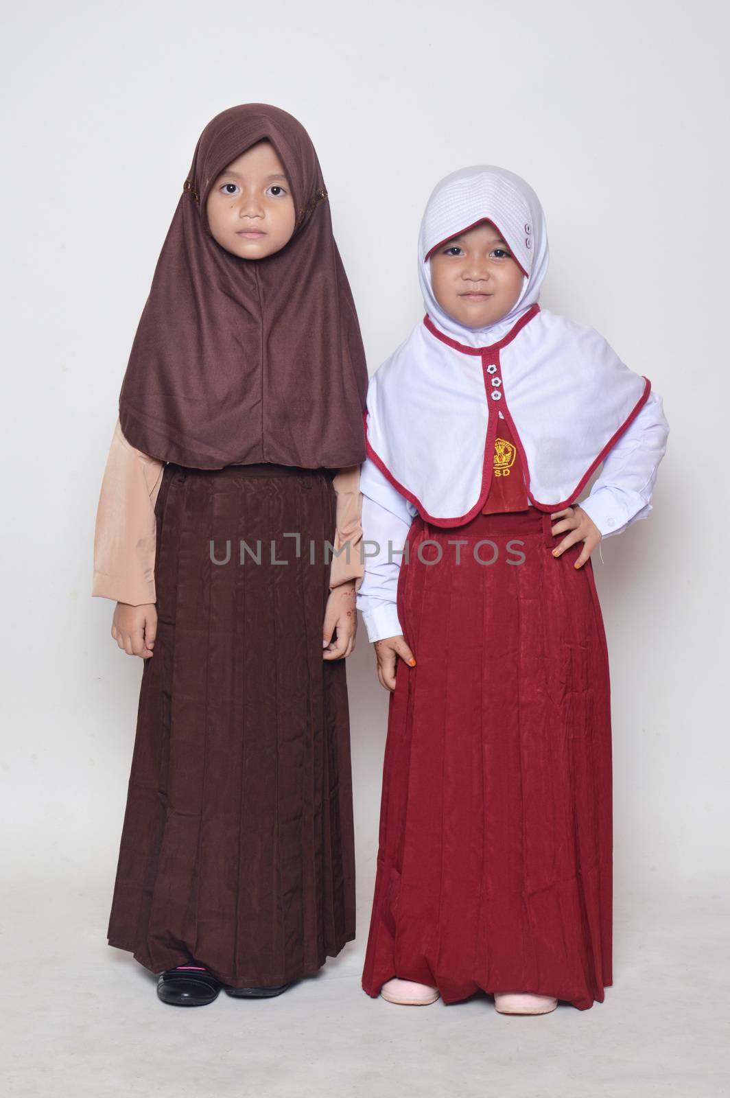 two asian little girl with primary school uniform and girl scout uniform