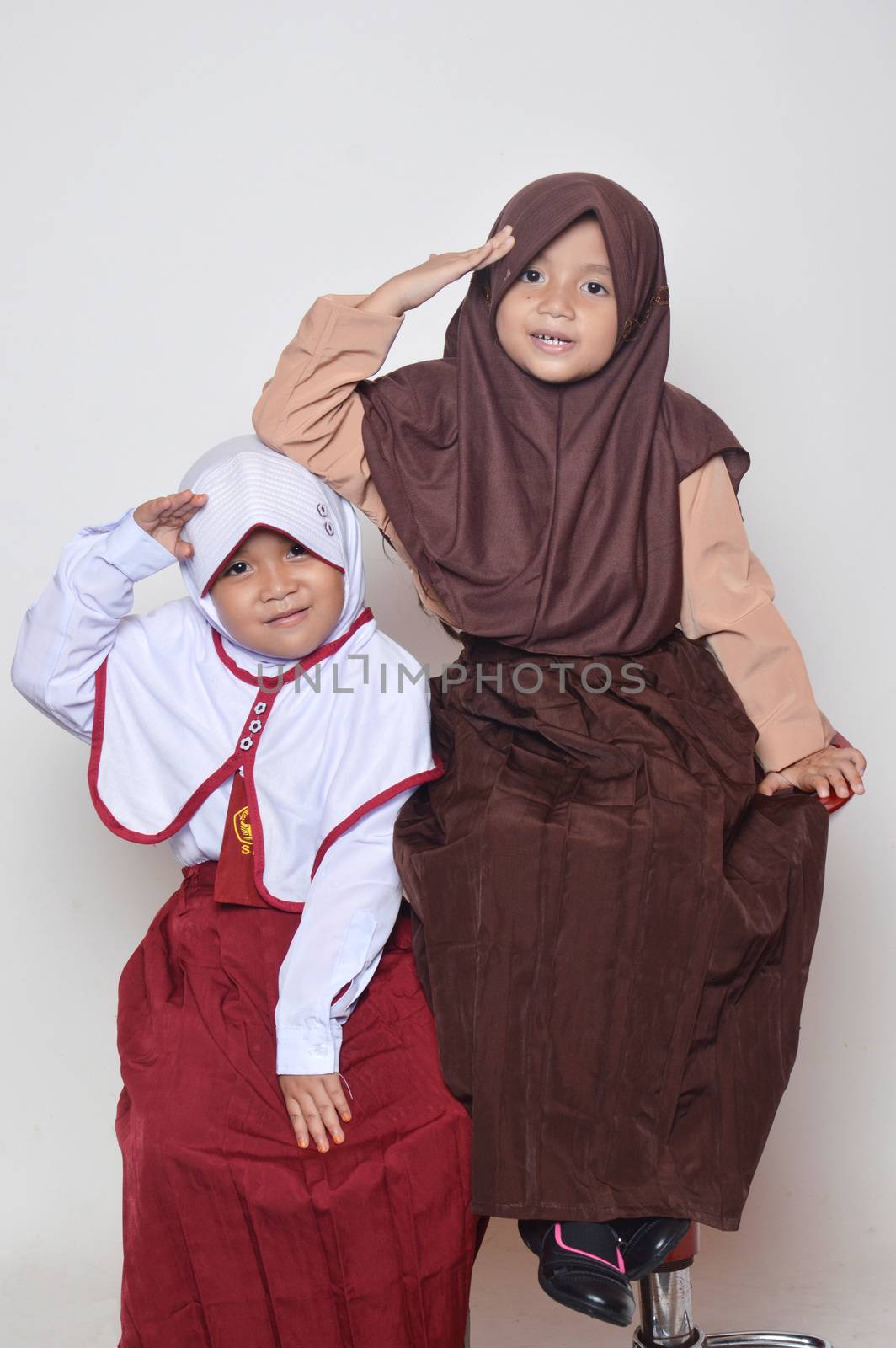 two asian little girl with primary school uniform and girl scout uniform