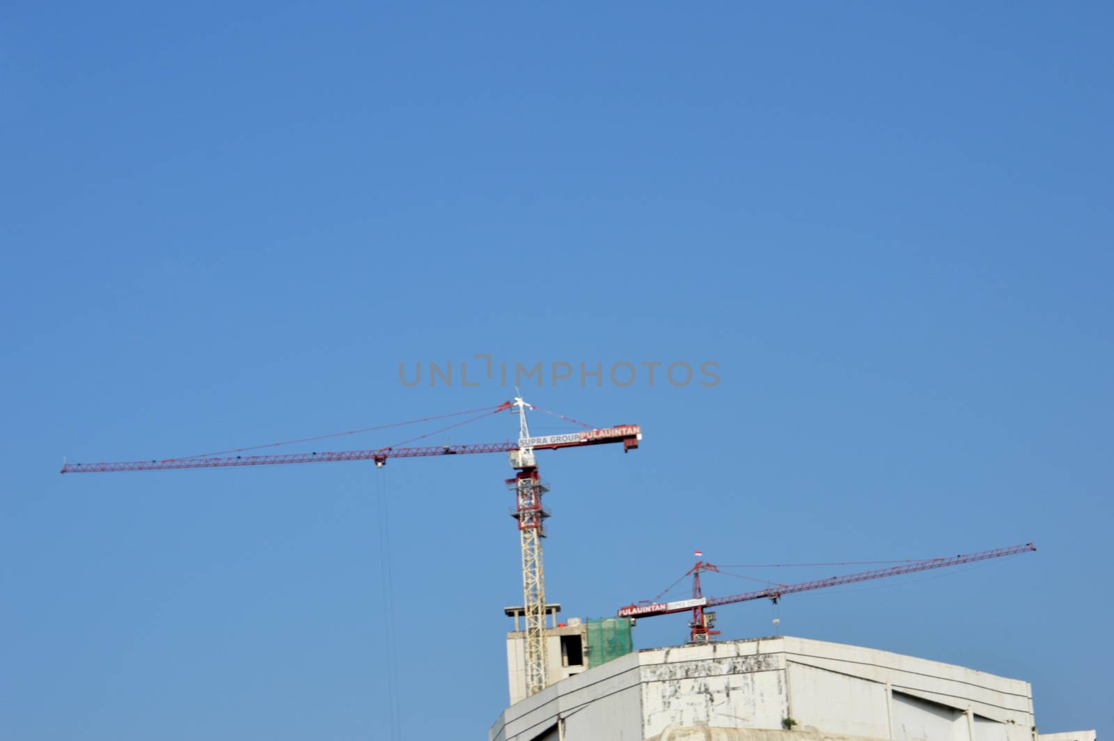 crane on a building in construction by antonihalim