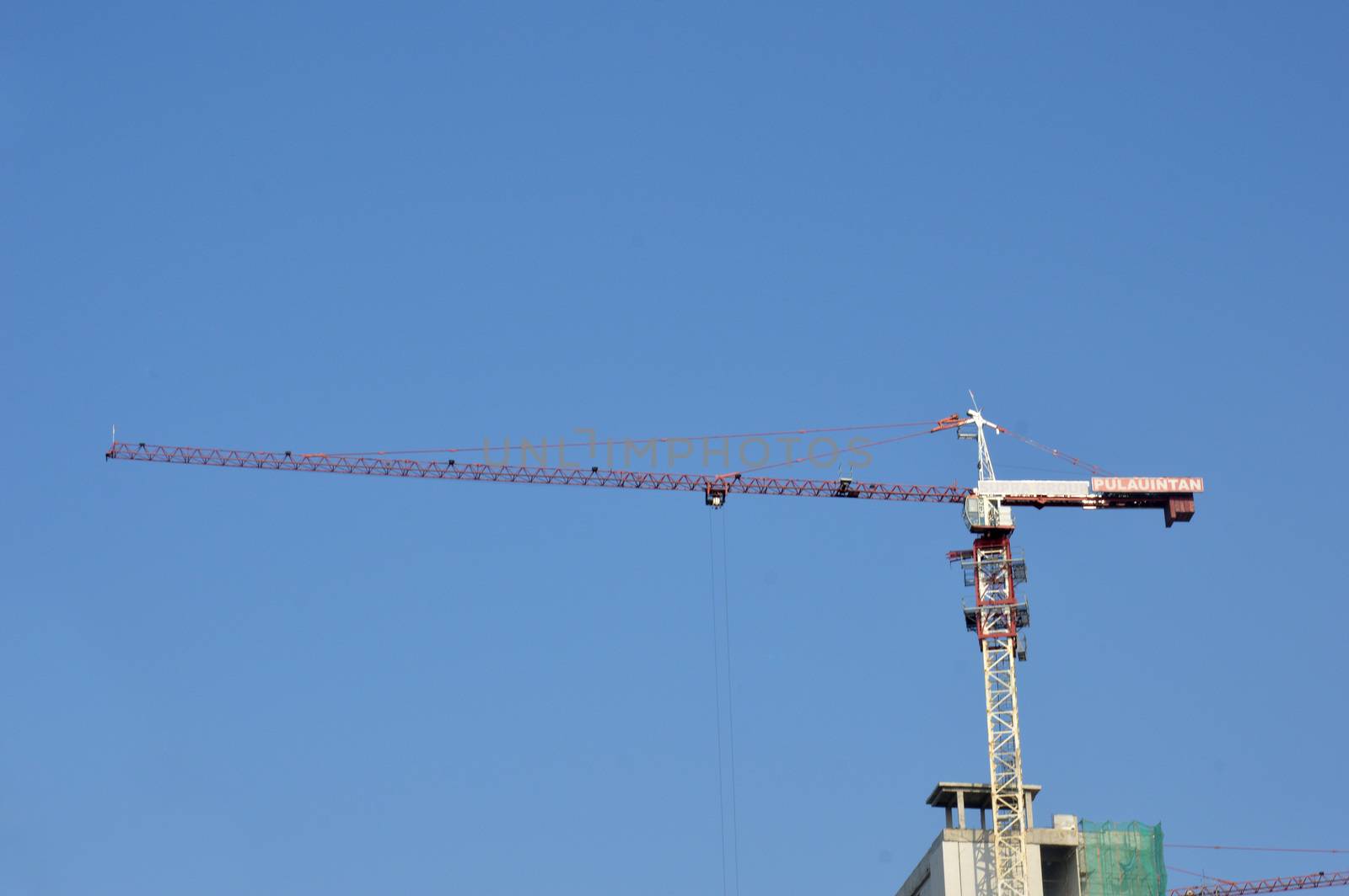 crane on a building in construction over blue sky