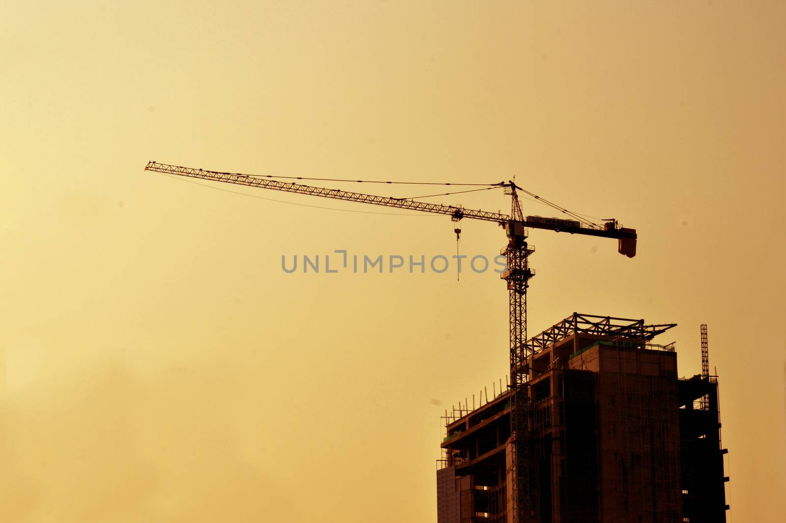 crane on a building in construction over sunset sky