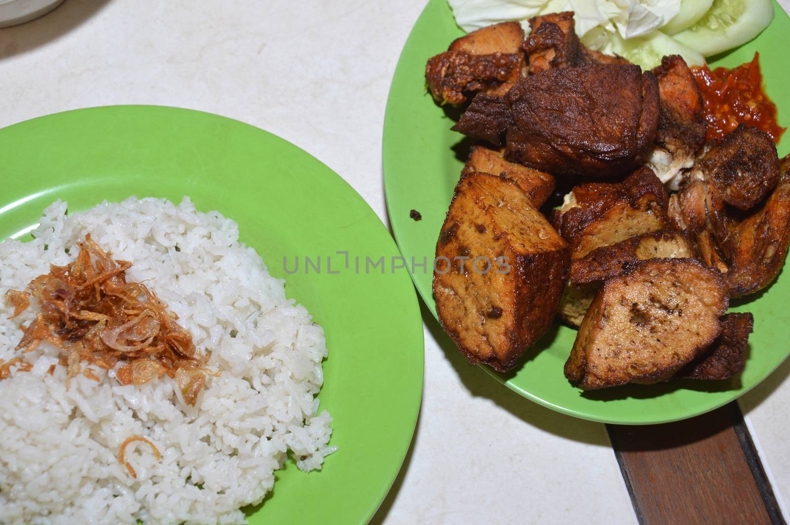 nasi uduk with a side dish of fried chicken and fried tofu, Indonesian traditional food, which is rice boiled in coconut milk
