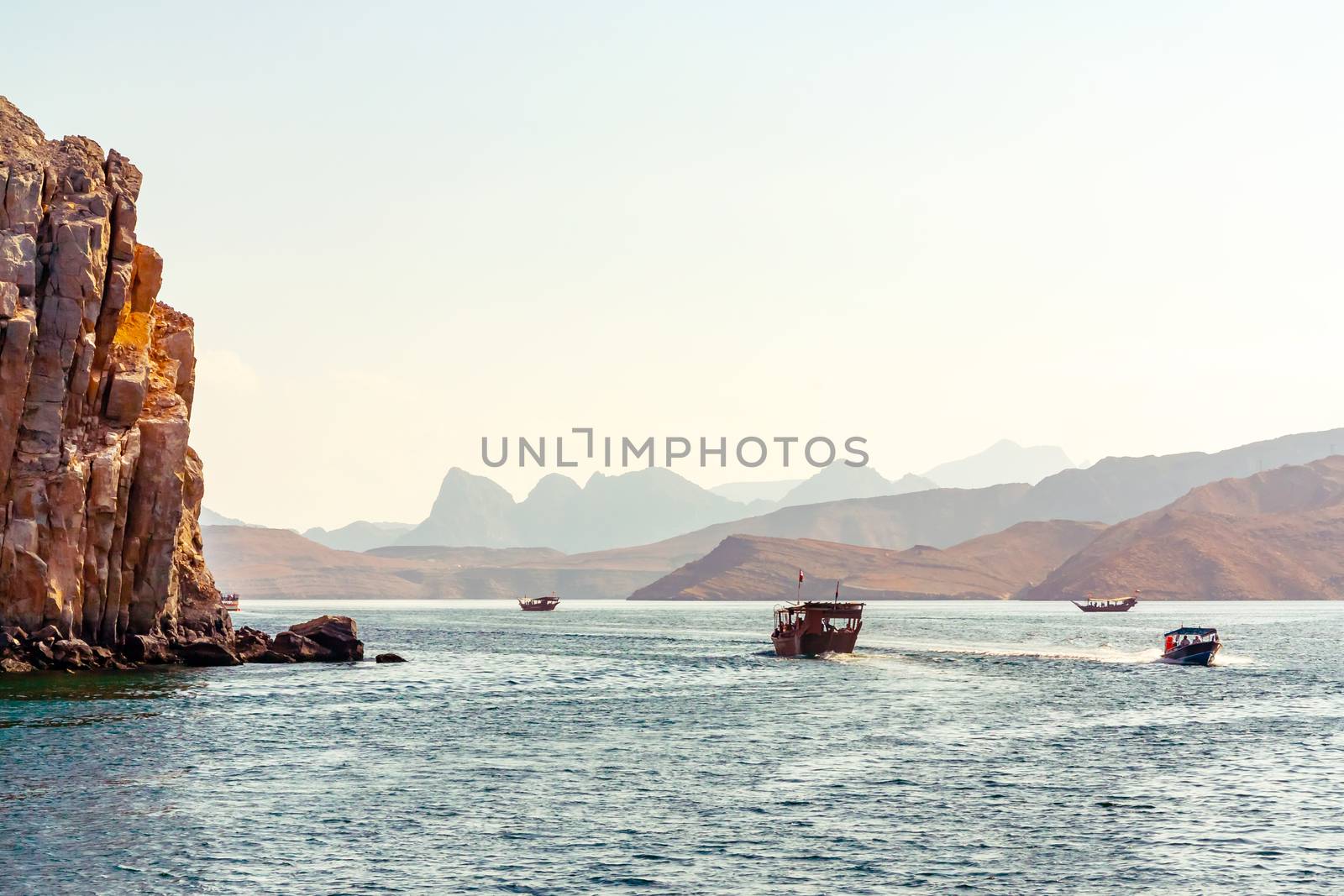 Sea, pleasure boats, rocky shores in the fjords of the Gulf of Oman by galsand