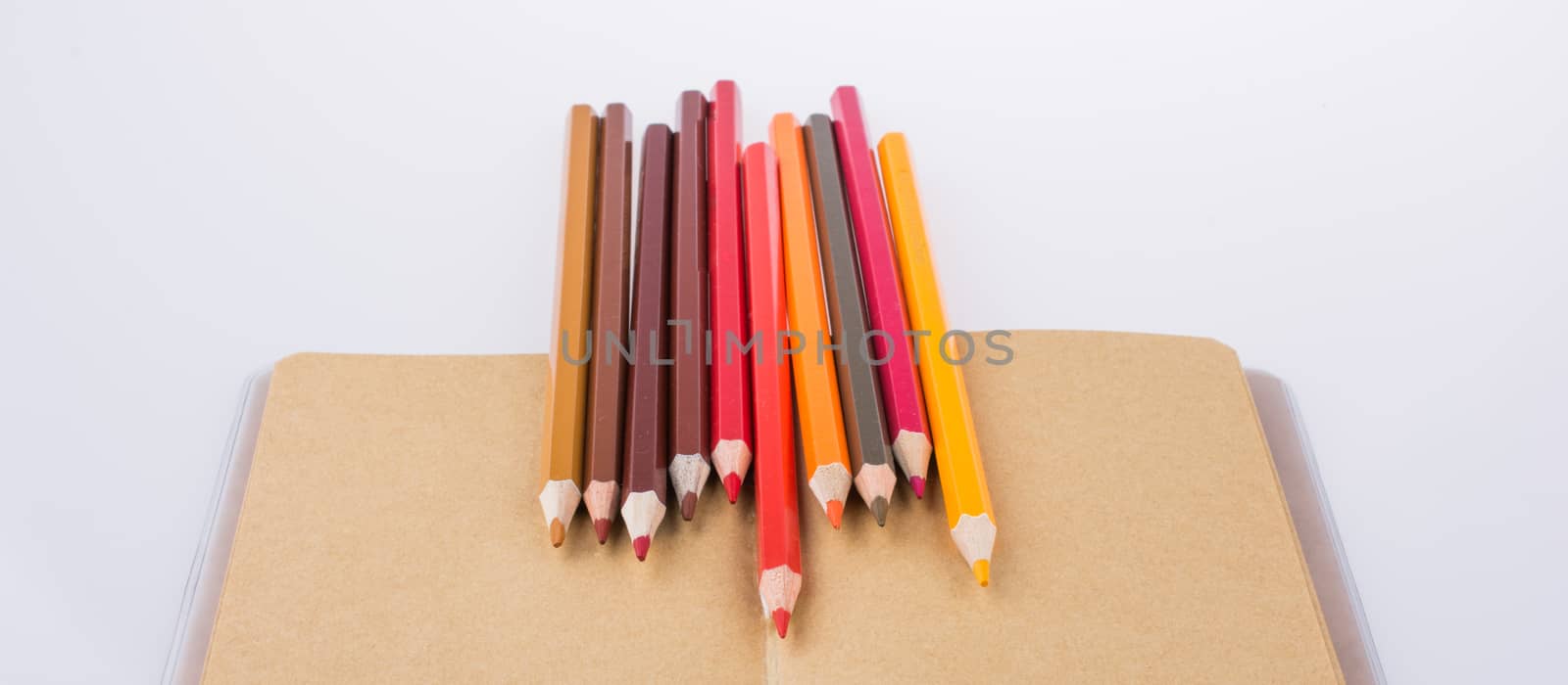 Color pencils placed on a notebook by berkay