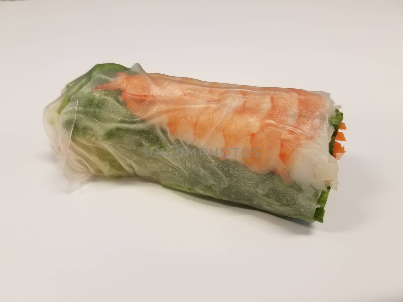 shrimp and lettuce and carrot rice paper roll on white desk or table