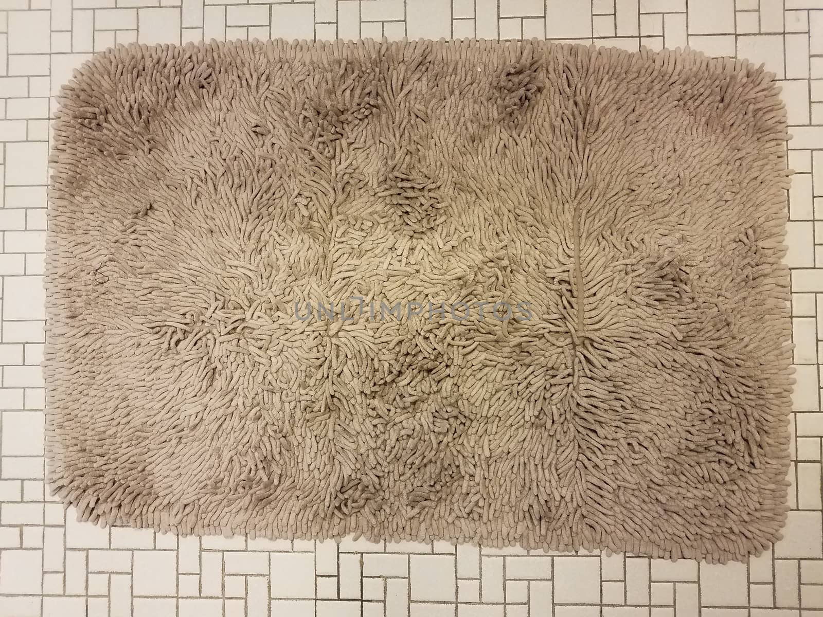 brown bathroom carpet or rug on white tile floor by stockphotofan1