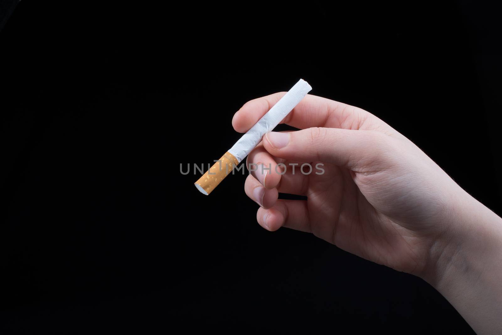 Hand is holding cigarette on a black background