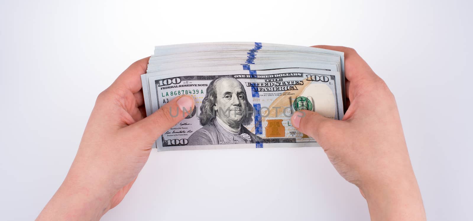 Human hand holding American dollar banknotes on white background by berkay