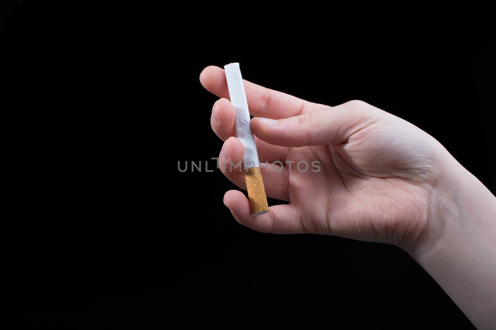 Hand is holding cigarette on a black background