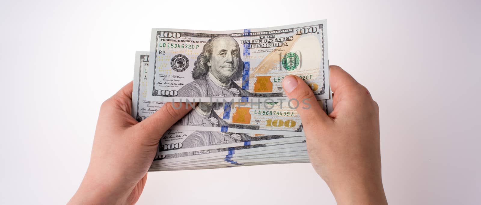 Human hand holding American dollar banknotes on white background by berkay