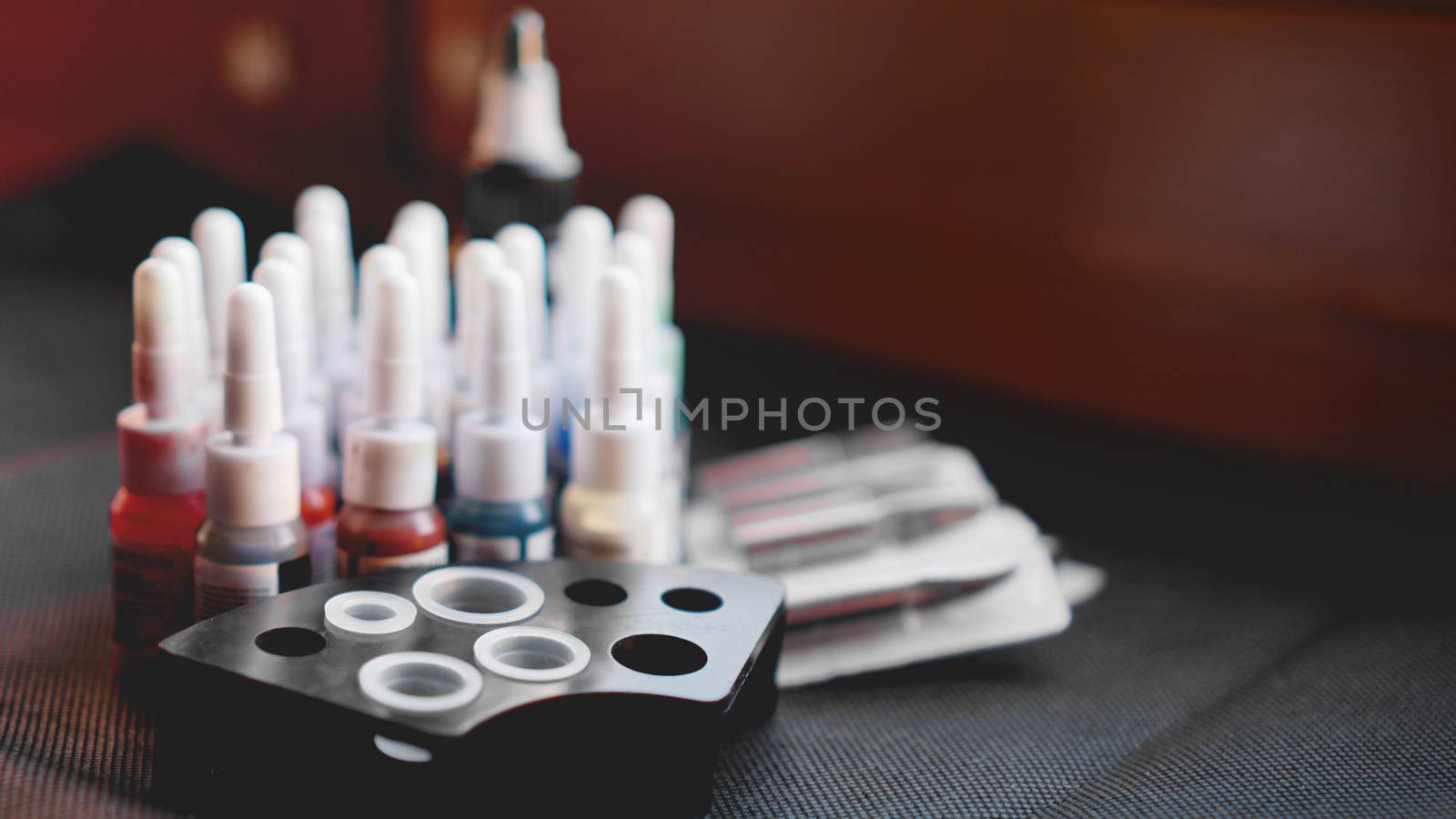 Many professional bottles with colored ink for tattoos - black background