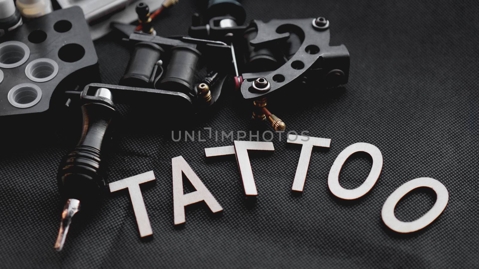 Tattoo accessories With the inscription tattoo of wooden letters on a black background.