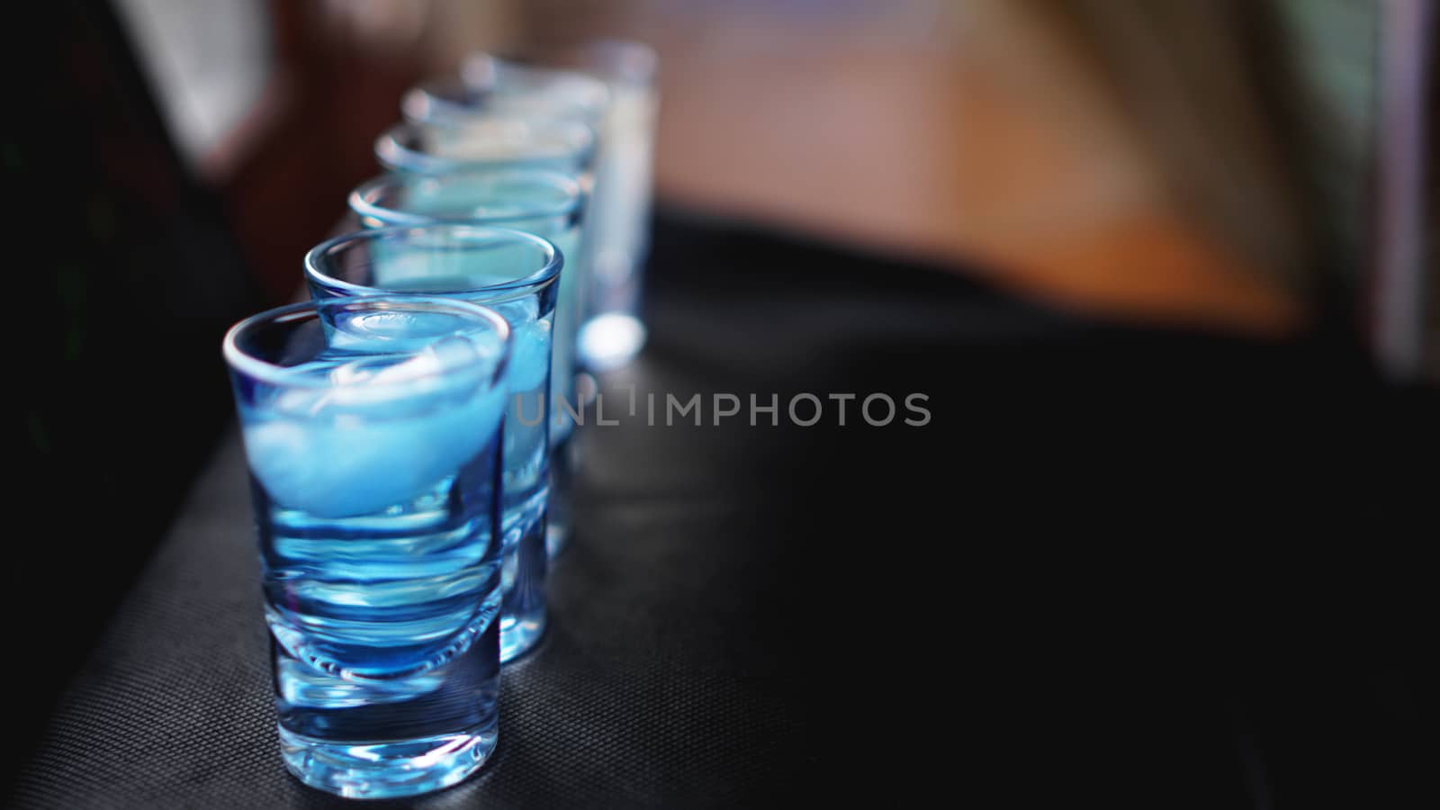 Glasses of vodka with ice. In bar - blurred background