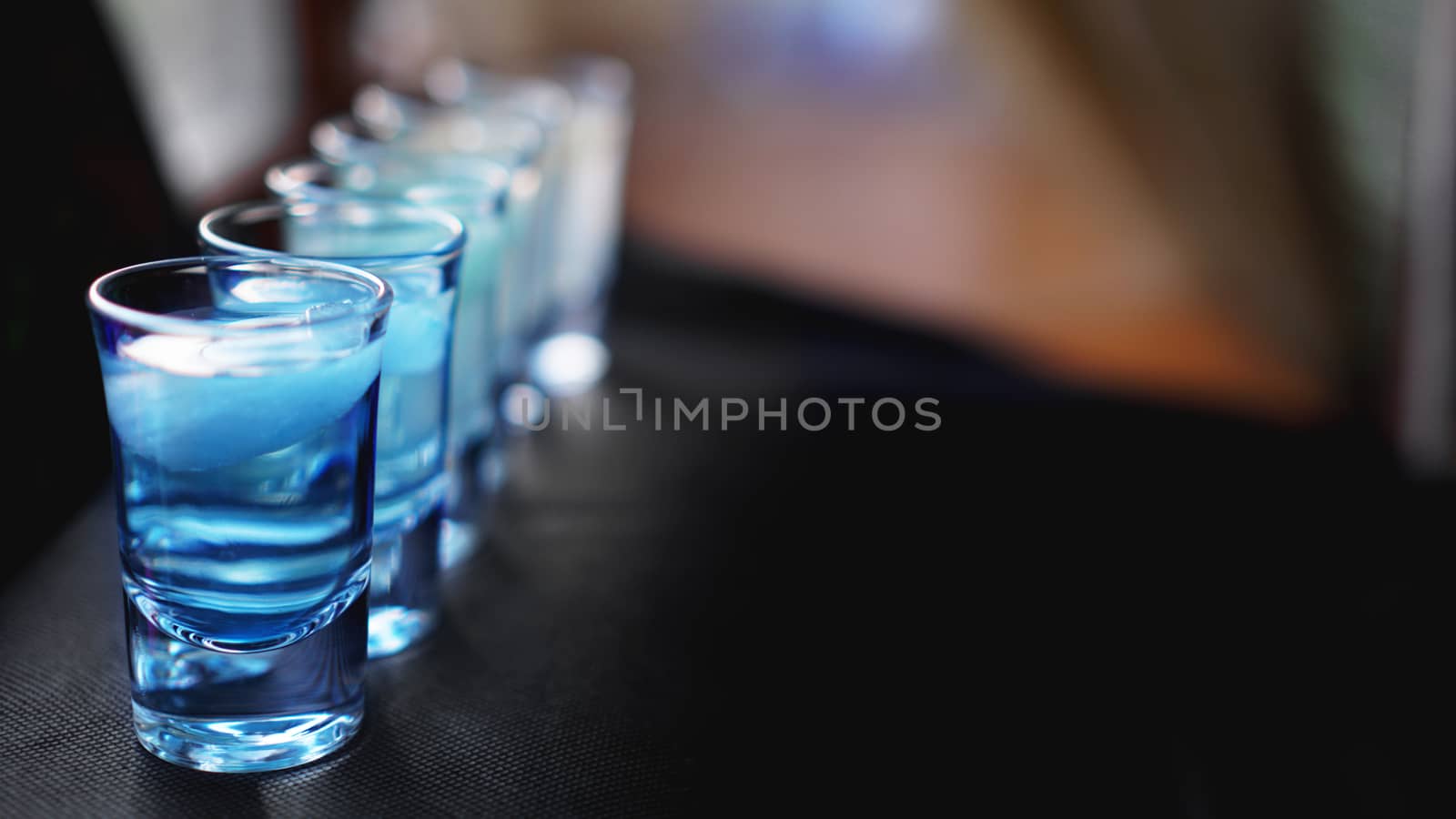 Glasses of vodka with ice. In bar - blurred background