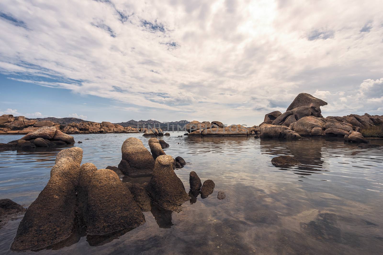 rounded rocks by the sea water in the beach of Testa di Polpo in La Maddalena, Sardinia, Italy
