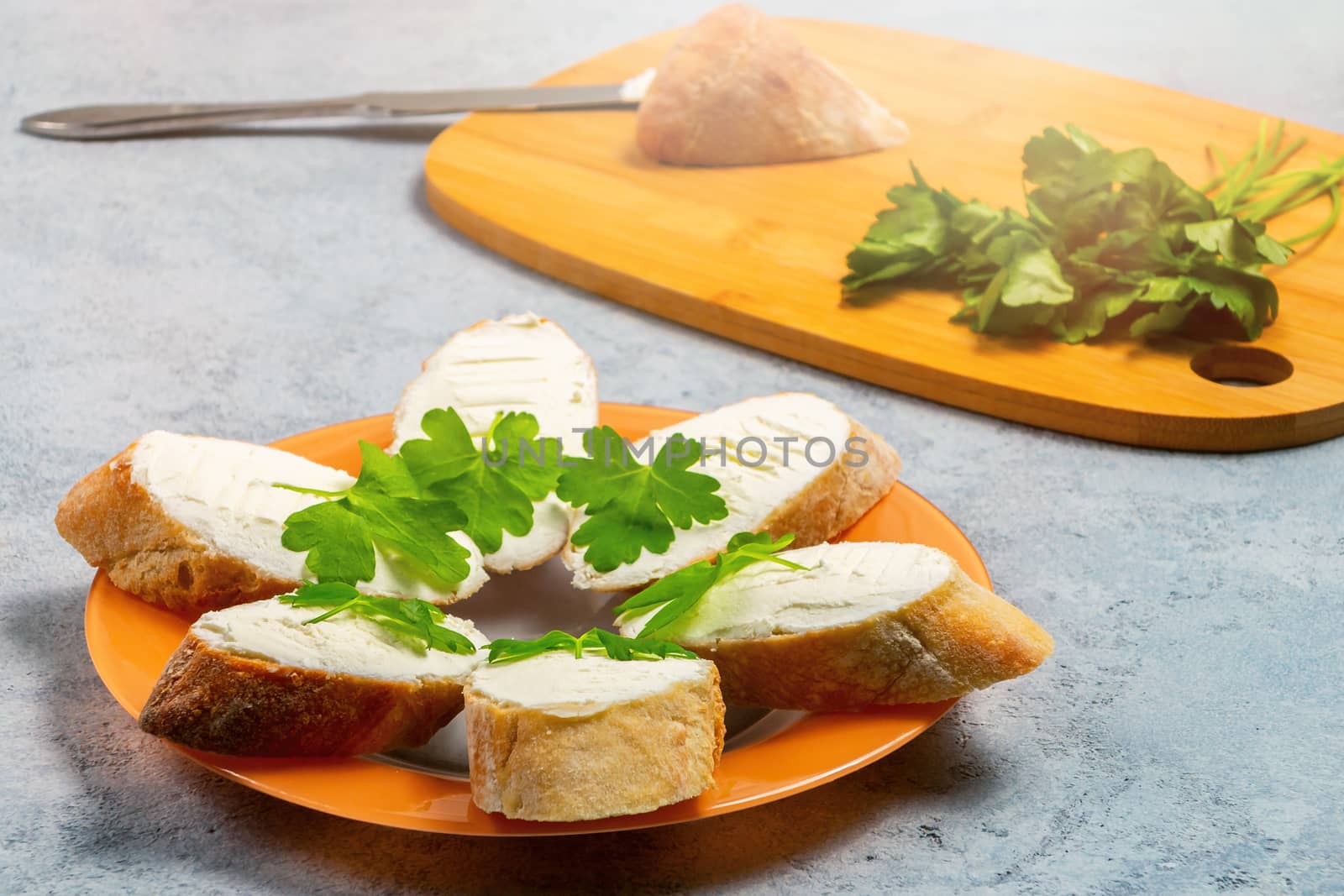 Freshly made Sandwiches with cream cheese on a plate on a gray table.